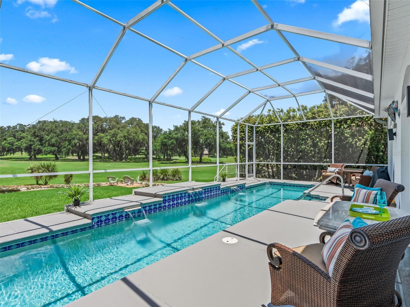 The screened lanai features a 36' x 8' heated lap pool, creating a private resort-style setting with beautiful views across the 10th fairway of Tierra Del Sol Championship Golf Course. - 714 CIMARRON AVE, THE VILLAGES