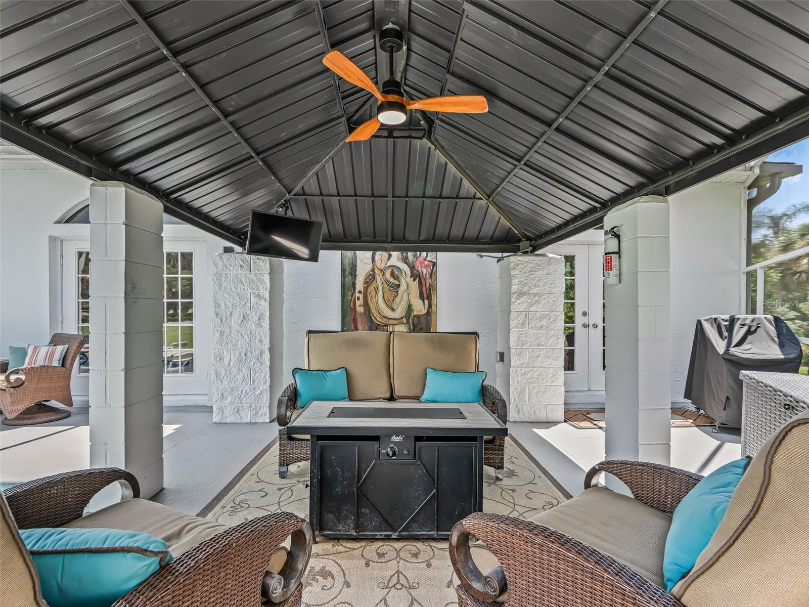 This substantial covered gazebo offers a comfortable extension of the home's living space, complete with ceiling fan and plenty of room for seating and outdoor entertaining. - 714 CIMARRON AVE, THE VILLAGES