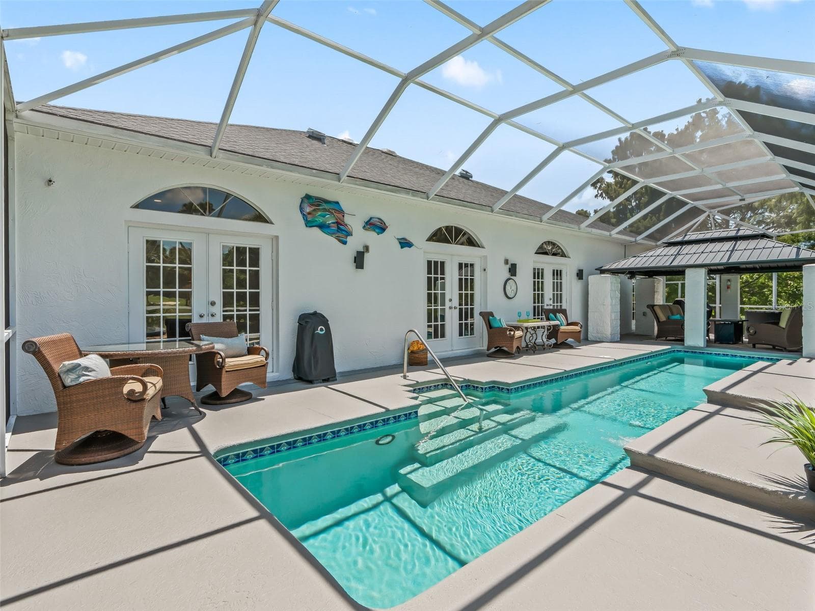 Wide view of the screened enclosure highlights the impressive pool length, spacious deck, multiple access points from the home, and abundant room for outdoor furniture. - 714 CIMARRON AVE, THE VILLAGES