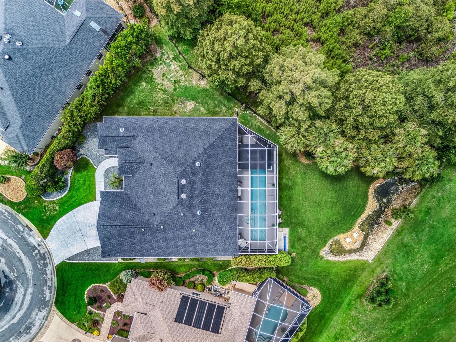 Top-down aerial view showcases the custom Premier home's expansive footprint, screened pool enclosure, oversized lot, mature landscaping, and desirable cul-de-sac setting. - 714 CIMARRON AVE, THE VILLAGES