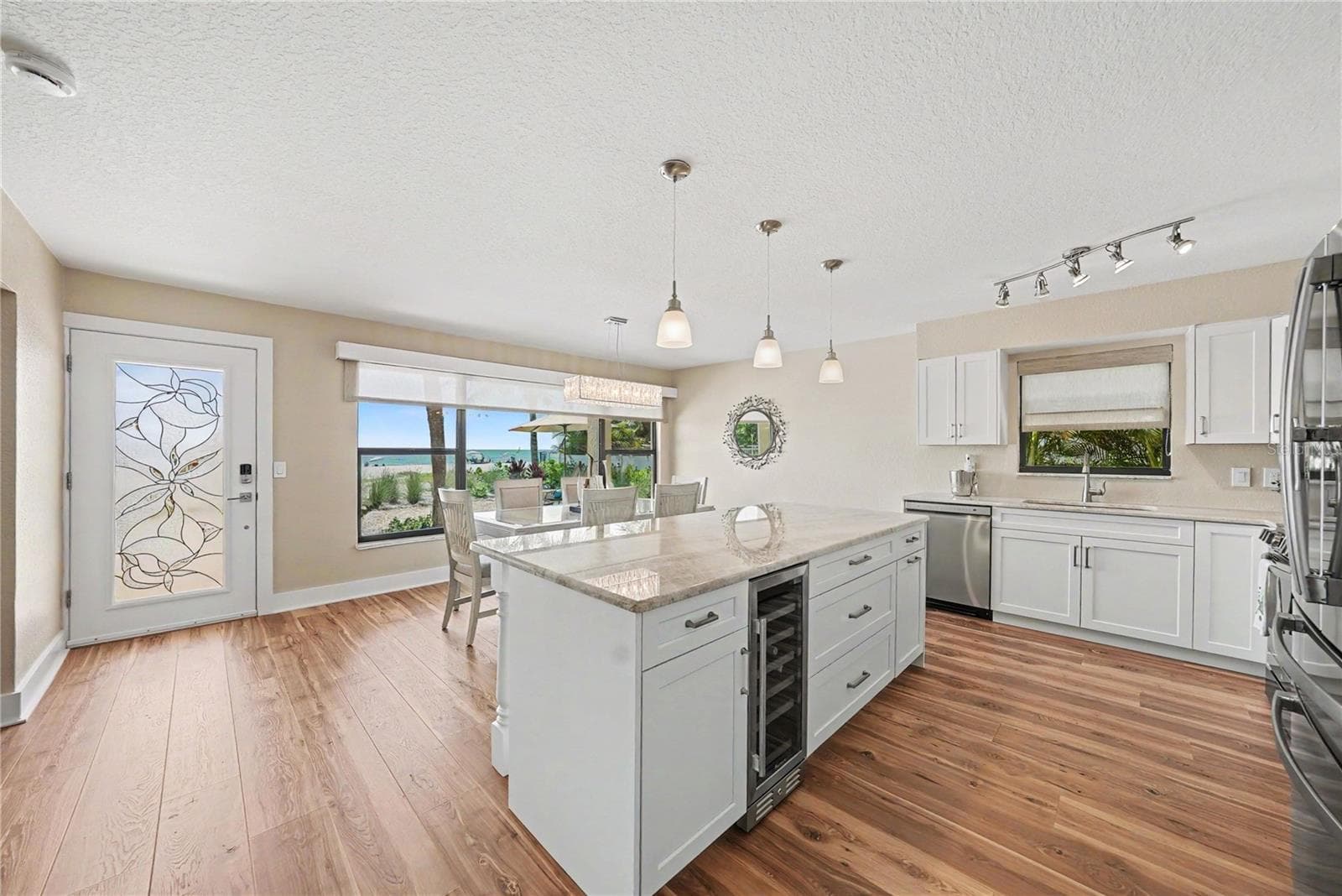 Quartzite counters, oversized kitchen island and space for a large dining room, new cabinets, appliances, 4" baseboards, paint, and flooring. Enjoy remote window shades with expansive views of the beach from both the living room and kitchen. Bonus kitchen window allows for Florida breezes too! - 19936 GULF BLVD, INDIAN SHORES