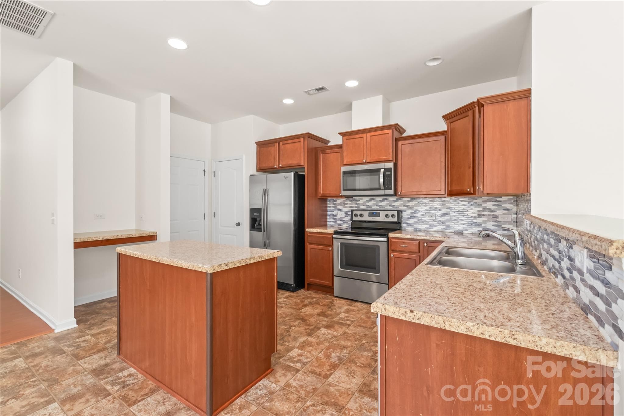 The kitchen has lots of cabinet space, a pantry, and a great nook for a coffee bar or drop zone. - 8411 Romana Red Lane, Charlotte