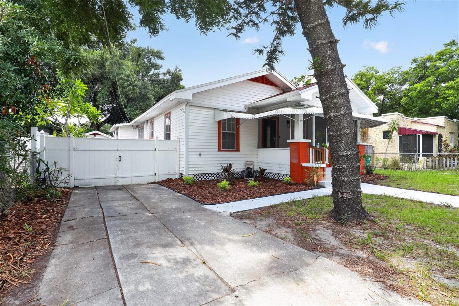 Side view of this classic 1922 bungalow showing the driveway and inviting curb appeal - 813 E NEW ORLEANS AVE, TAMPA