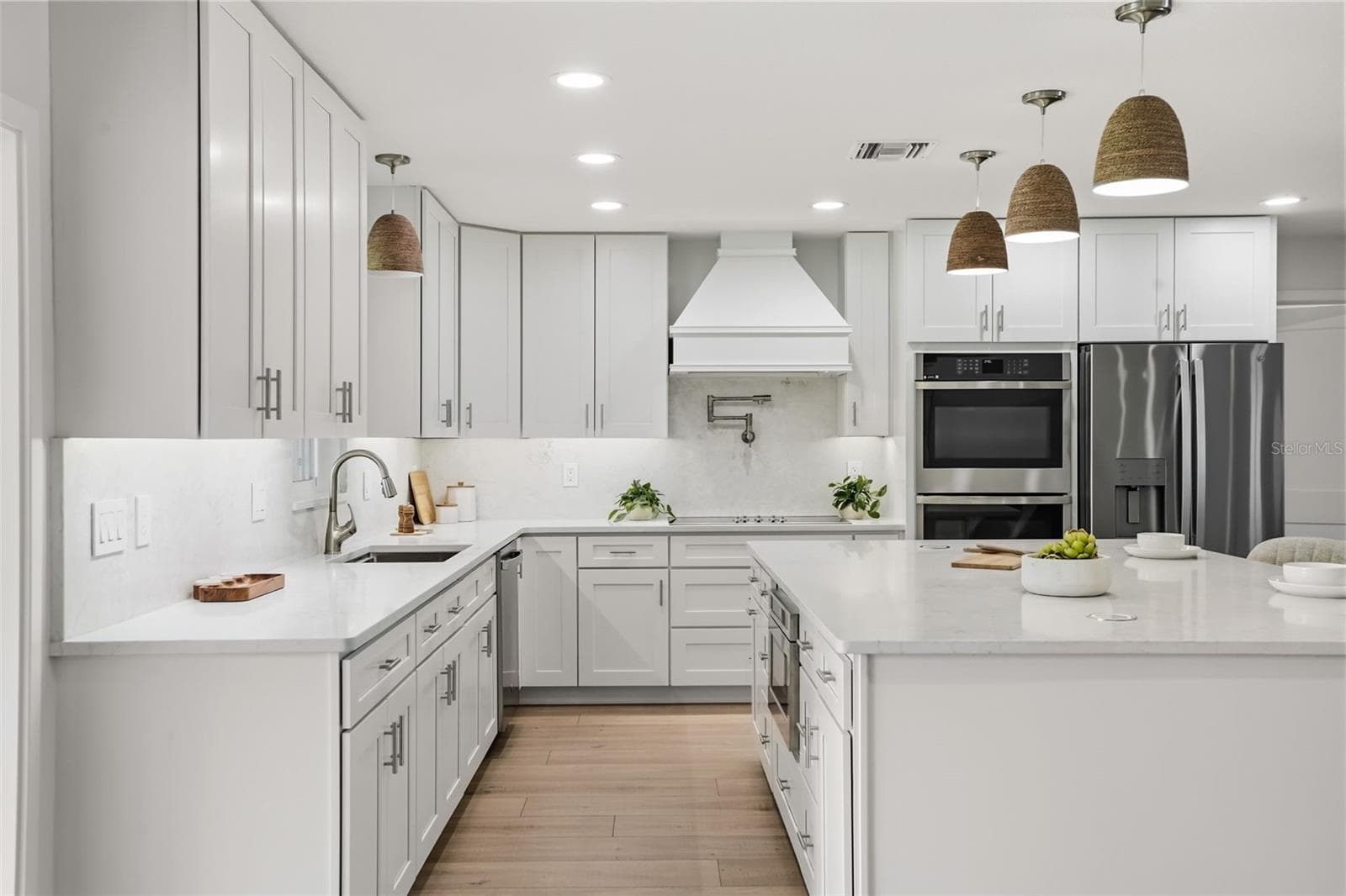 At the heart of the home, this beautifully designed kitchen features quartz countertops, custom cabinetry, premium appliances, and an oversized island perfect for gathering. - 39251 COUNTY ROAD 439, UMATILLA