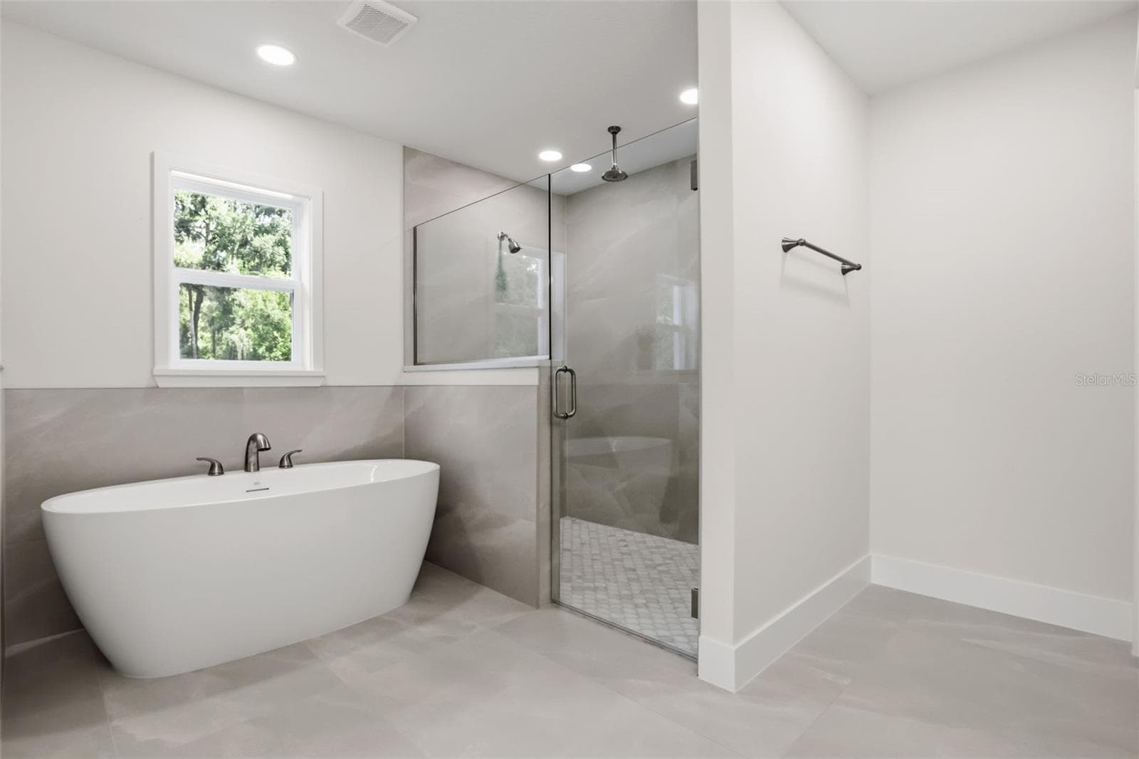 Retreat to the beautifully appointed primary bathroom featuring a spa-like soaking tub, walk-in glass shower, and timeless finishes throughout. - 39251 COUNTY ROAD 439, UMATILLA