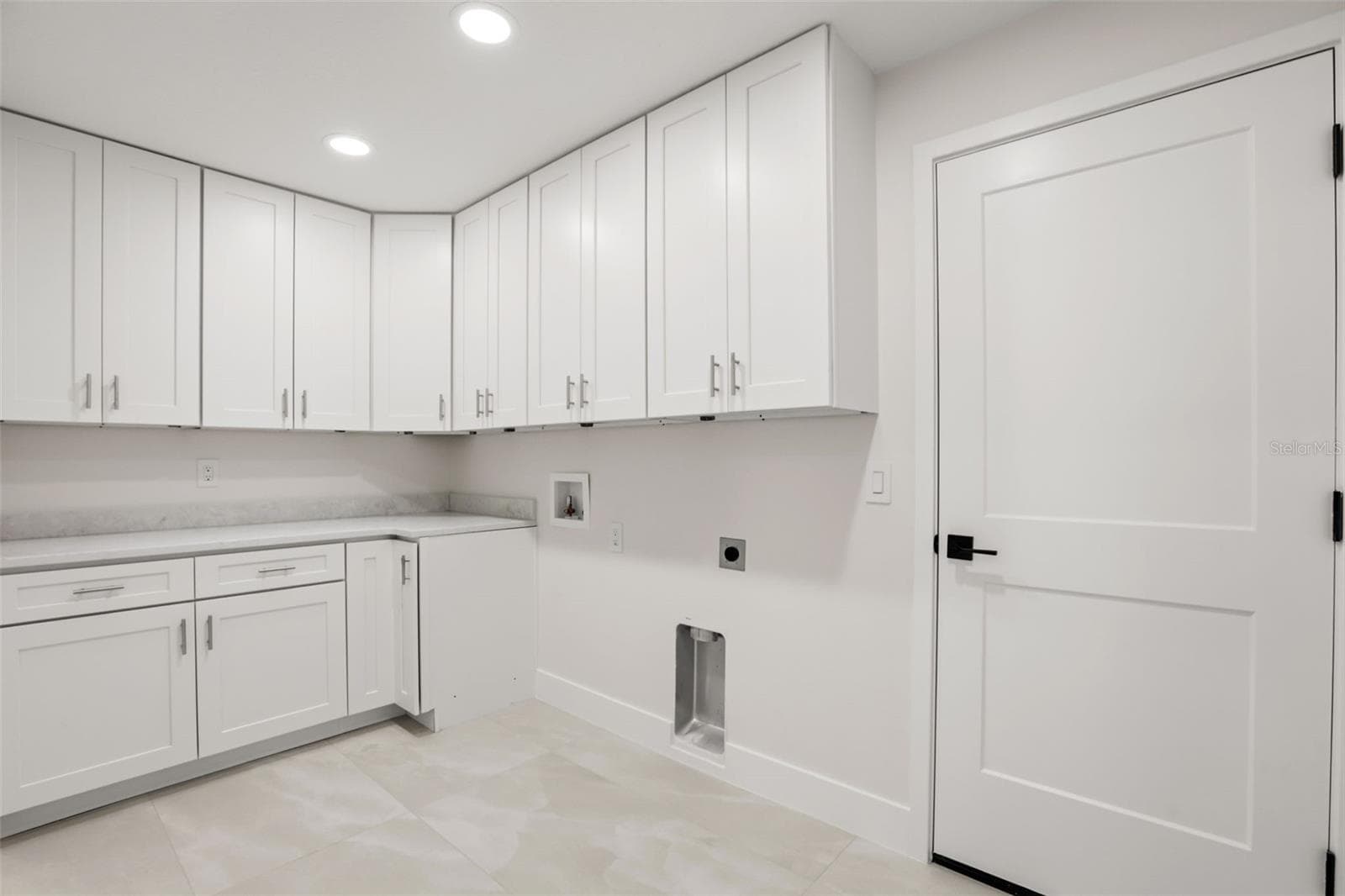 Bright and functional laundry room featuring extensive cabinetry, plenty of counter space, and a clean, modern design. - 39251 COUNTY ROAD 439, UMATILLA