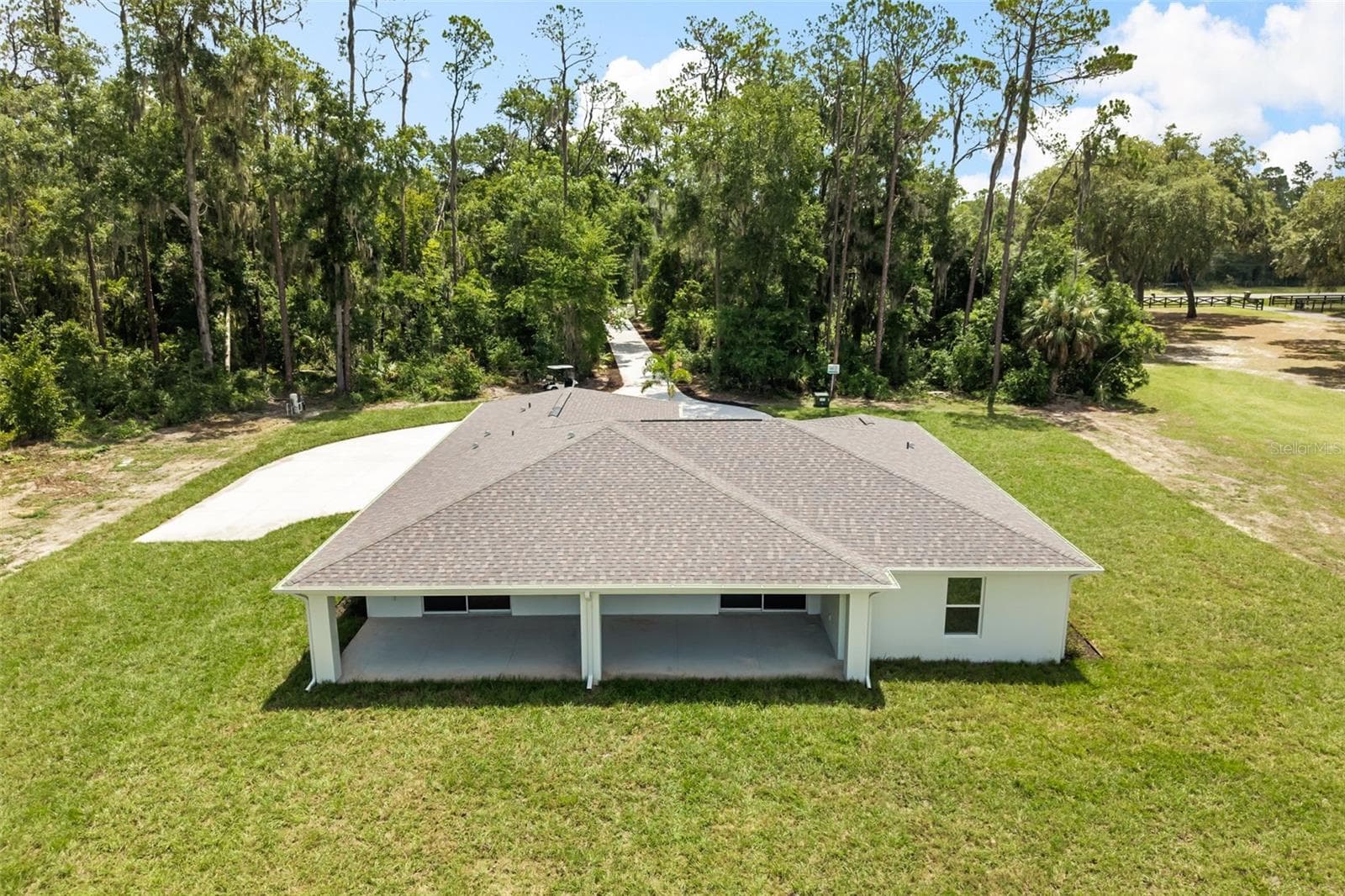 Aerial rear view showcasing the expansive backyard, outdoor living area, and private setting. - 39251 COUNTY ROAD 439, UMATILLA