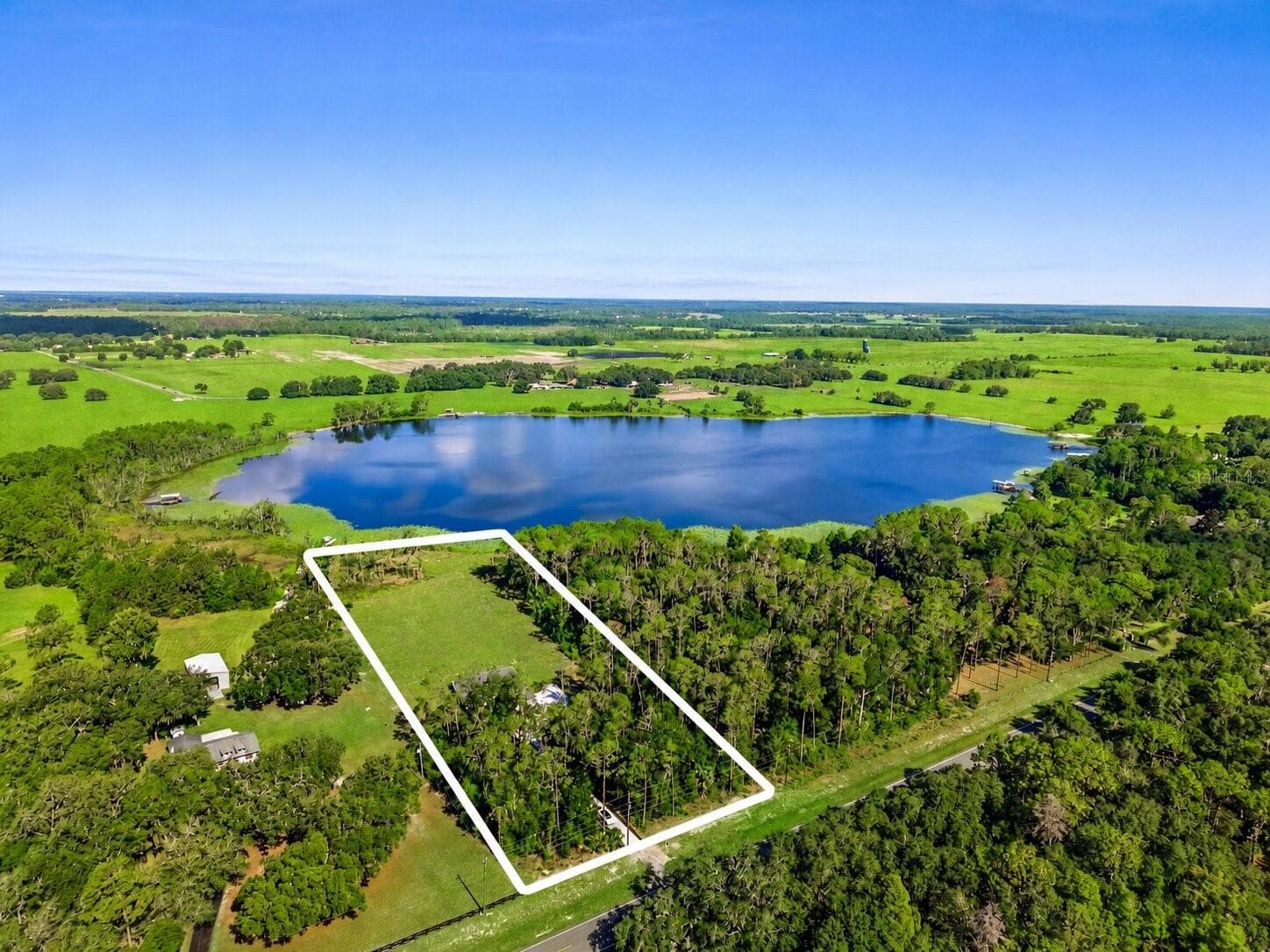 Elevated aerial view showcasing the full parcel with boundary lines for reference. - 39251 COUNTY ROAD 439, UMATILLA