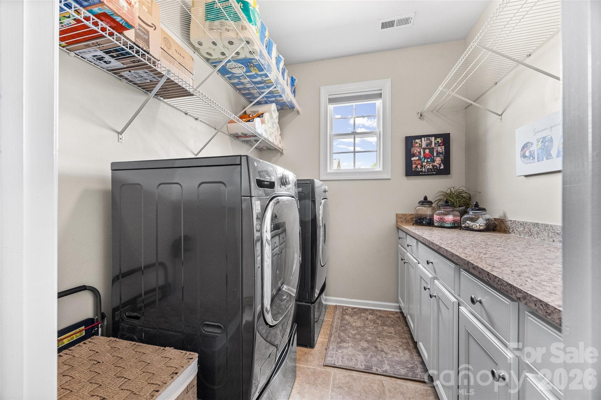 Laundry room with plenty of cabinets and counter space. - 8621 Sequoia Grove Lane, Charlotte
