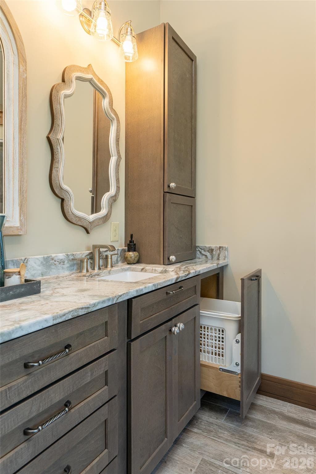Custom pull-out hamper drawers on each side of the vanity add convenience and functionality to the primary bath. - 660 Pleasant Grove Road, Hendersonville