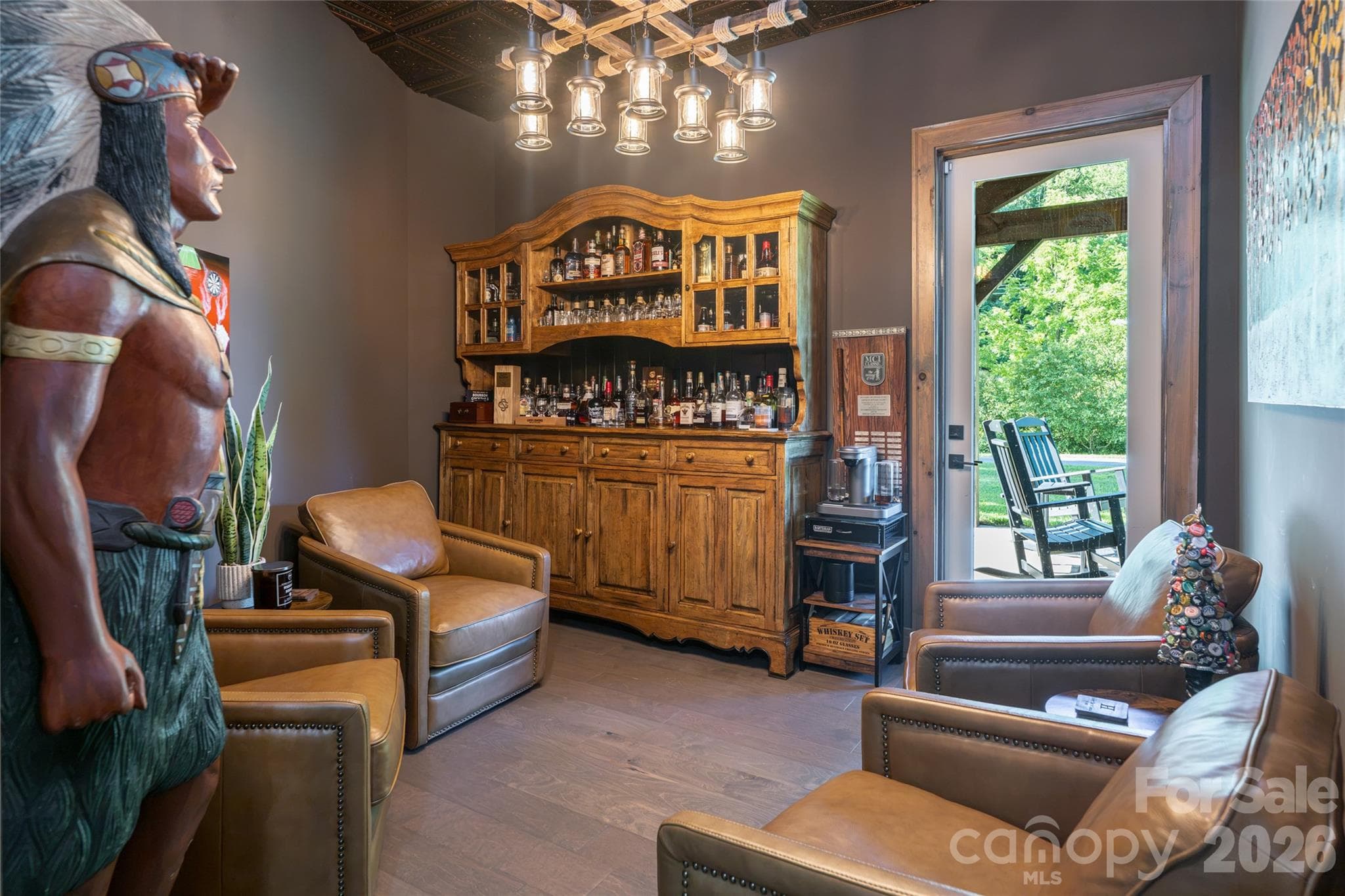 Versatile bonus room currently used as a bourbon/cigar retreat, featuring direct access to a covered patio. - 660 Pleasant Grove Road, Hendersonville