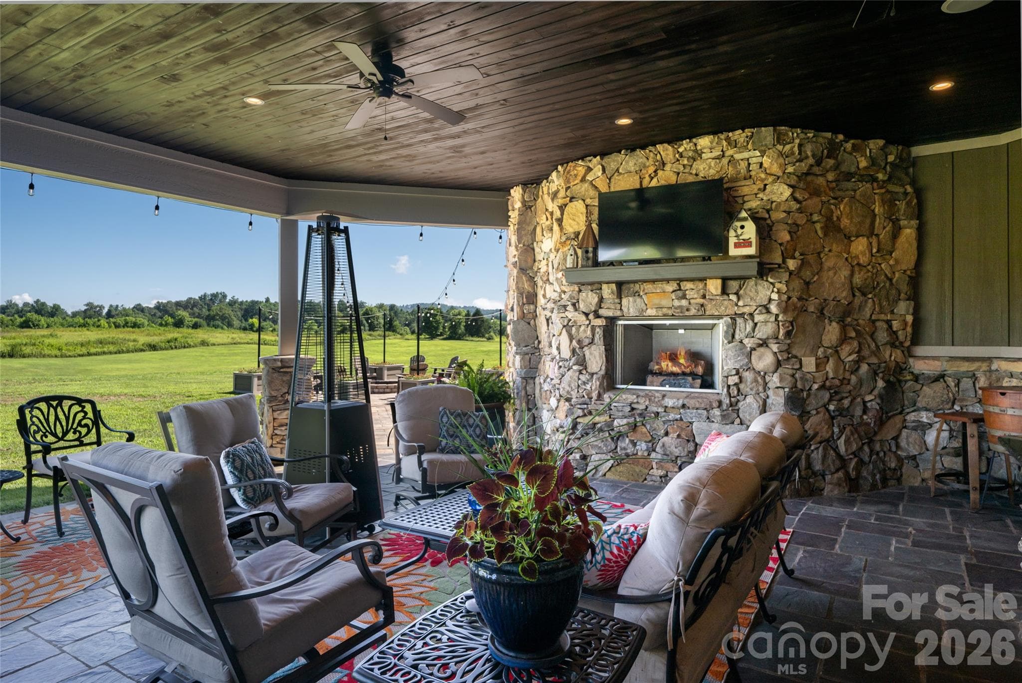 Covered patio features gas fireplace, slate flooring and an expansive view. - 660 Pleasant Grove Road, Hendersonville