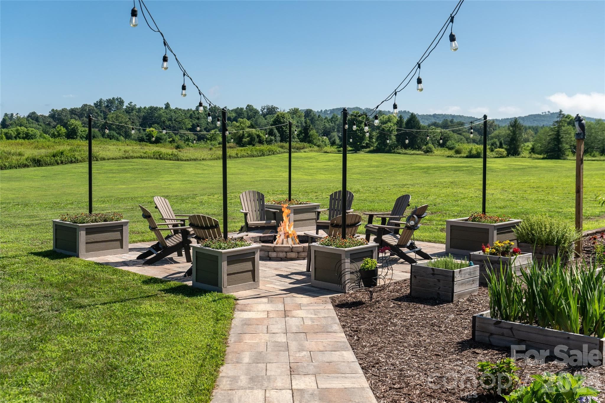 Fire pit off entertaining patio with great mountain views looking toward Jump Off Rock. - 660 Pleasant Grove Road, Hendersonville