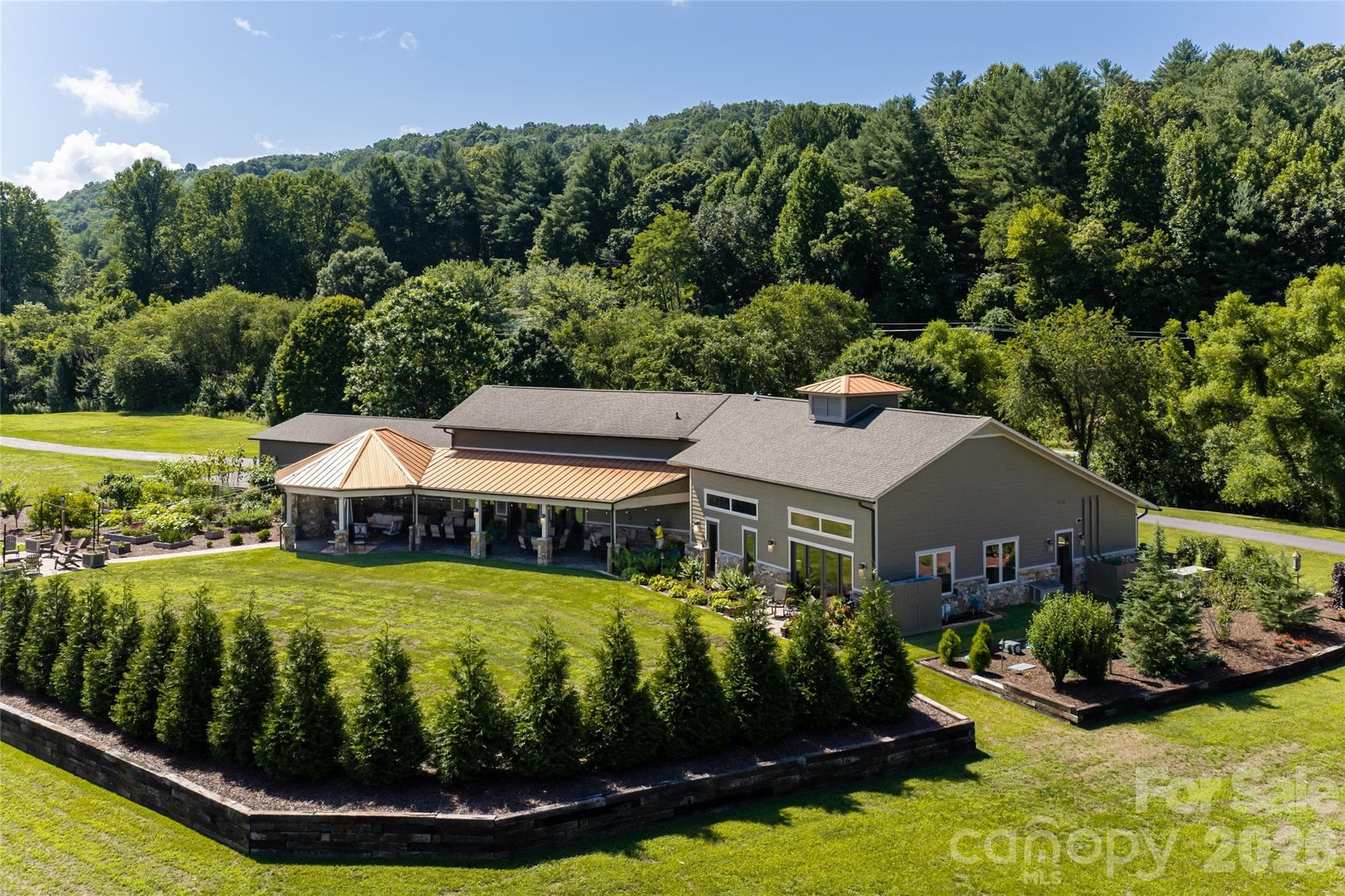 Beautifully landscaped rear exterior showcasing the home’s private backyard setting. - 660 Pleasant Grove Road, Hendersonville