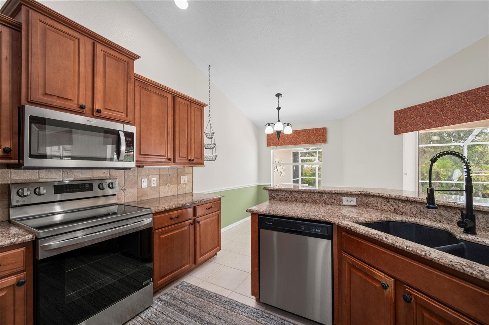 Kitchen with wood cabinetry, well equipped and breakfast nook. - 5615 MOJAVE AVE, NORTH PORT
