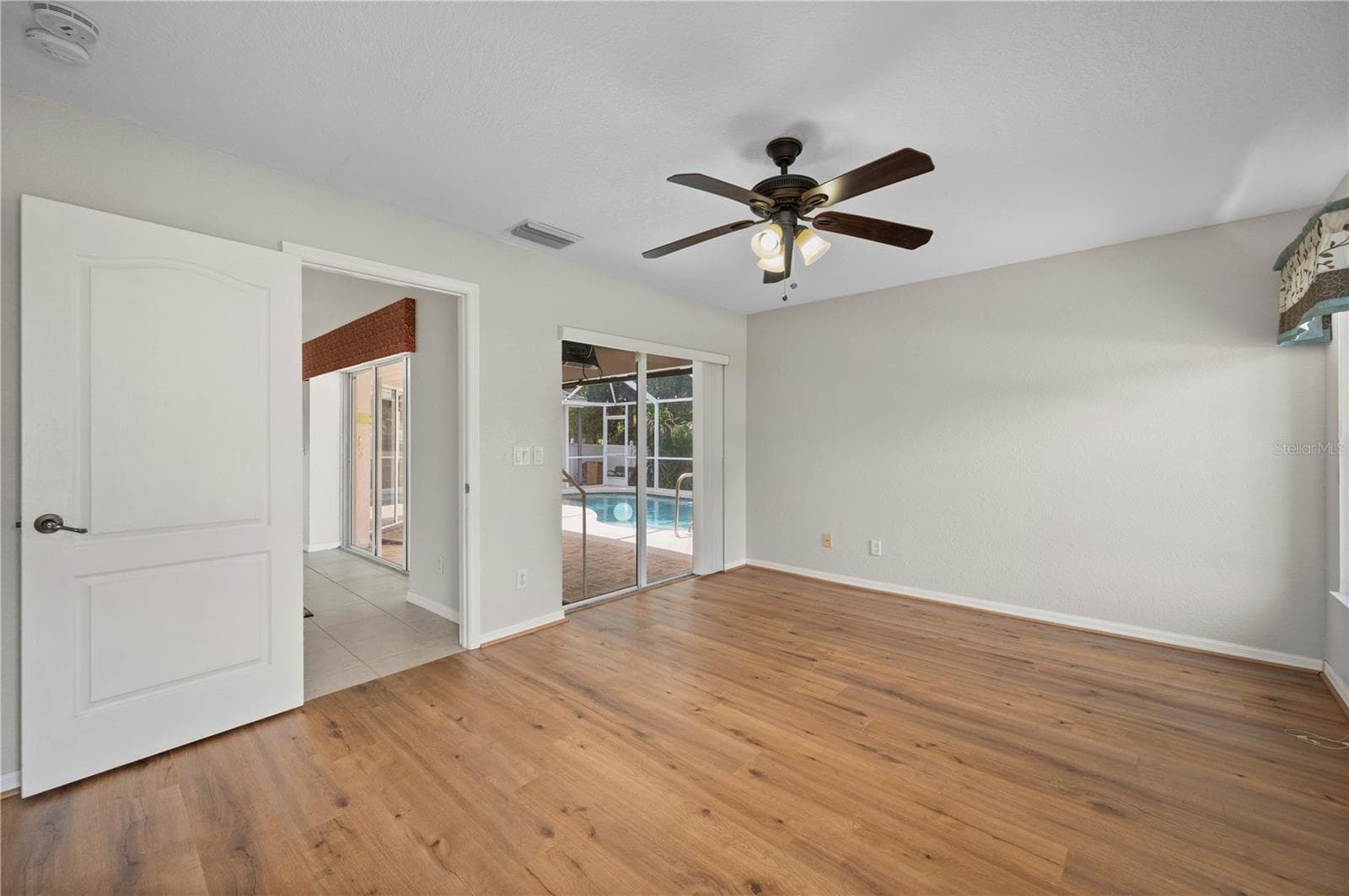 From the Primary Bedroom step into the Living Room or out to the lanai and pool area. - 5615 MOJAVE AVE, NORTH PORT