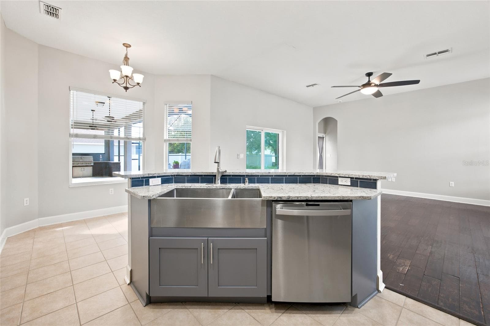 Remodedled Kitchen with Quartz Countertops with Island and Sunken Sink over looking Family Room and Pool - 5517 GREYSTONE DR, SPRING HILL