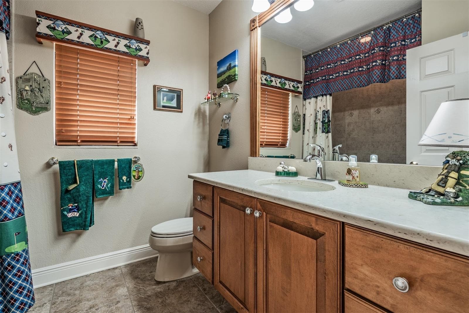 Guest/hall bathroom with golf themed motif! - 34115 AMERICANA AVE, DADE CITY