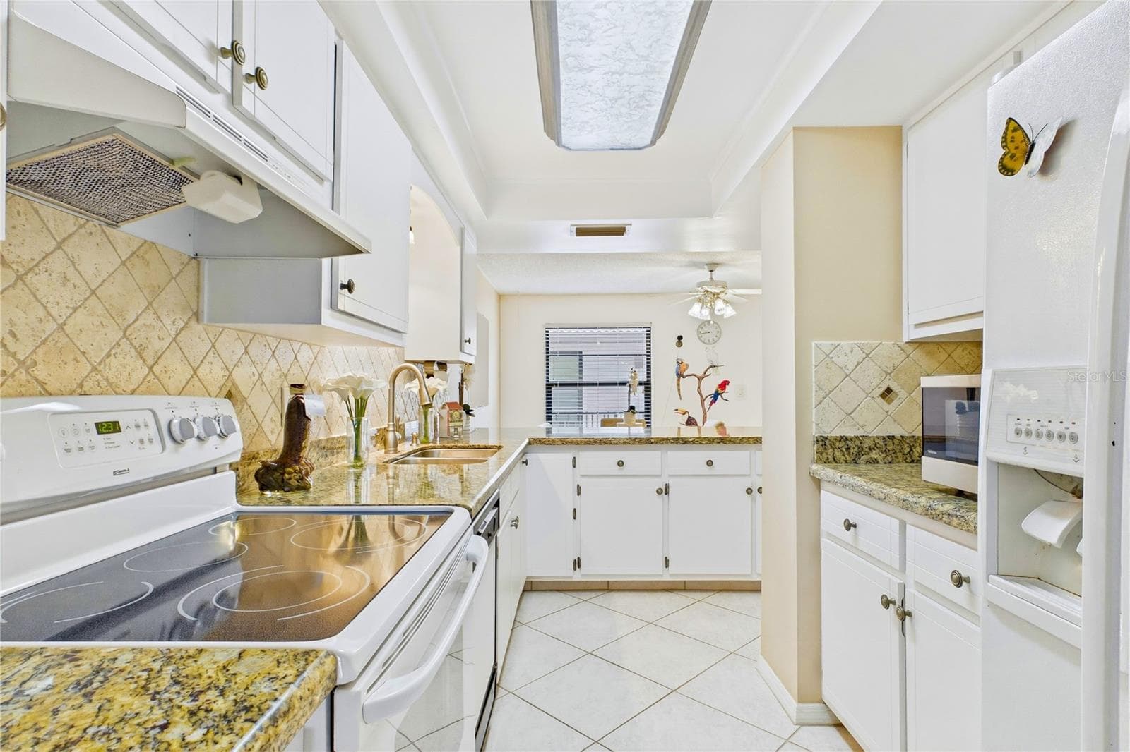 Bright galley kitchen with abundant cabinet and counter space - 4218 SE 20TH PL #D5, CAPE CORAL