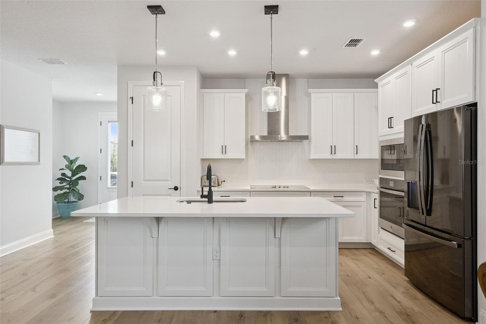 The Premium Kitchen showcases Timberlake 42" cabinet soft close uppers with crown molding, custom trash drawer, Carrara Morro Quartz Countertops, Hexagon Backsplash and Closet Pantry. - 2954 JOURNEY PL, ST CLOUD