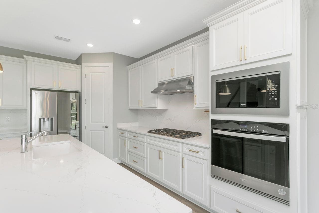 Luxury Kitchen with Large island, built in oven, closet pantry, custom fixtures, solid backsplash - 9909 LONGMEADOW AVE, PARRISH