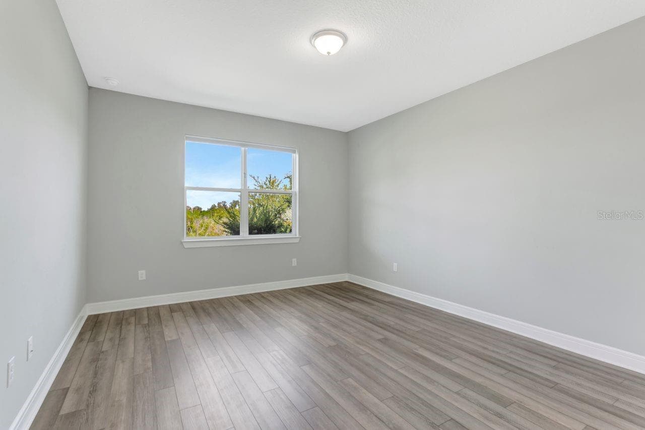 Primary Bedroom - 1st Floor, with backyard views,  luxury vinyl flooring with Ensuite Bath and Walk in Closet - 9909 LONGMEADOW AVE, PARRISH