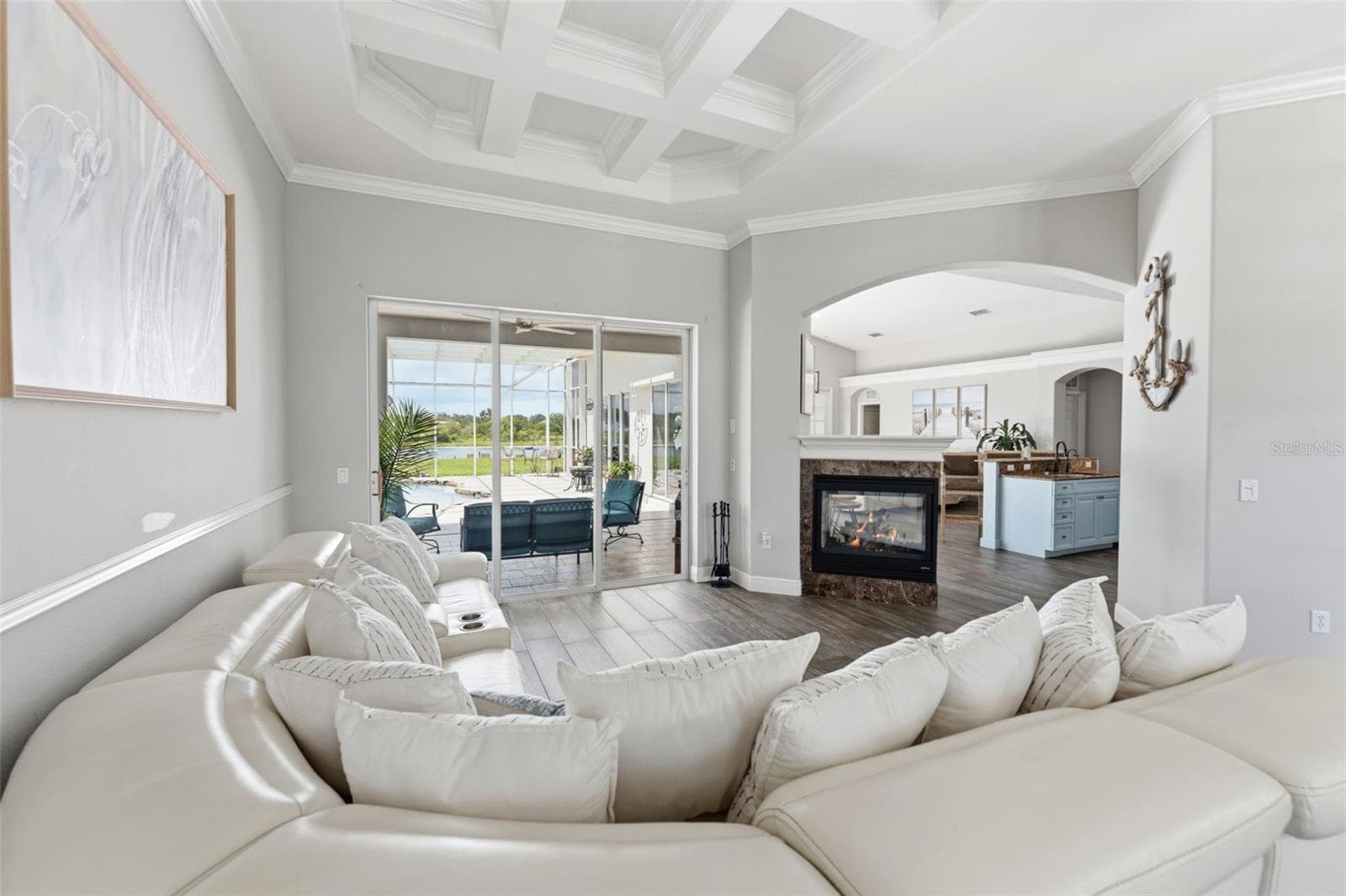 Enjoy the Formal Living Room, Featuring Serene Water Views and a Cozy Fireplace. - 24355 HIDEOUT TRL, LAND O LAKES
