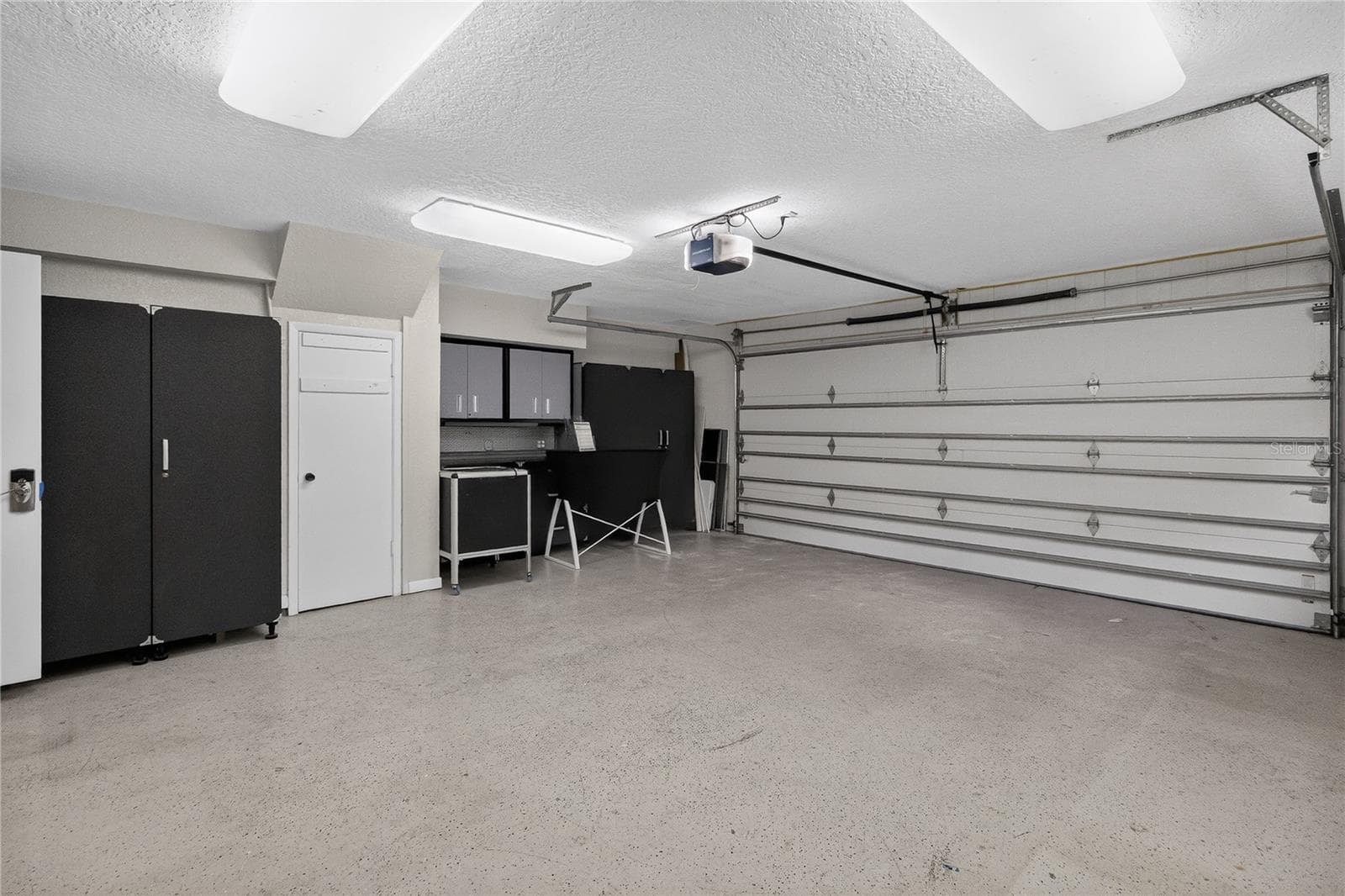 View 2 -Garage w/ cabinetry, shelving strategically placed electrical outlets throughout w/ WORKSHOP lighting. - 656 LITTLE WEKIVA RD, ALTAMONTE SPRINGS