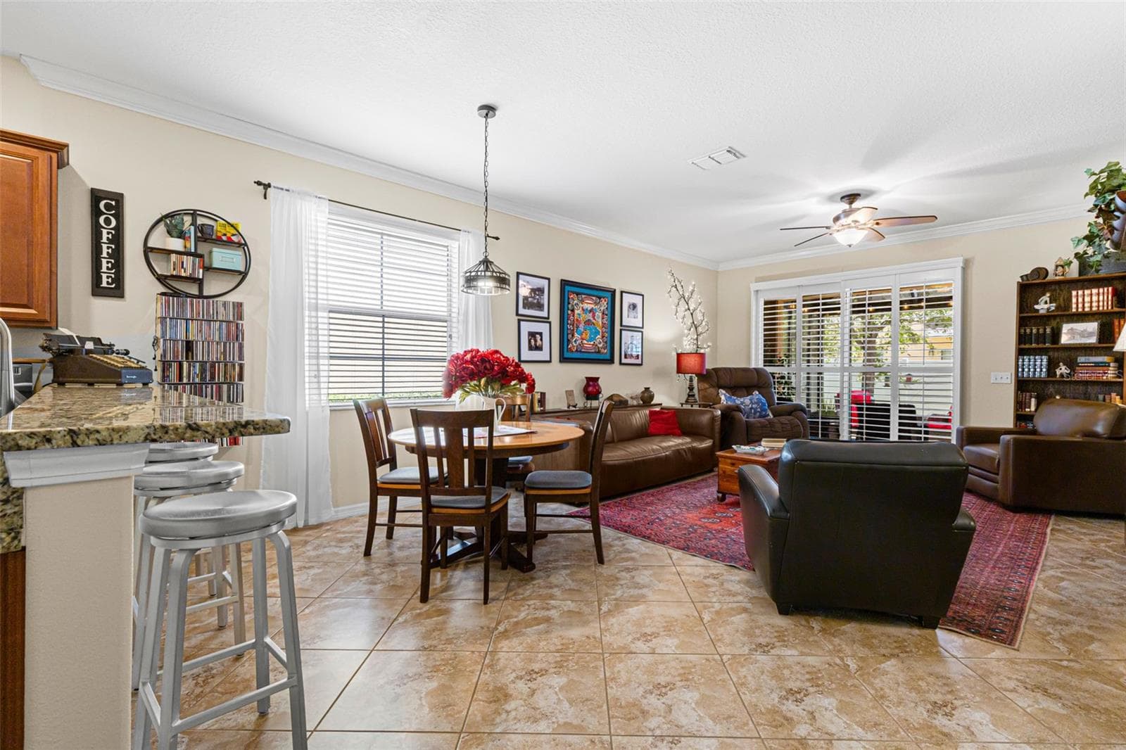 The dining area sits naturally between the kitchen and living room, while plantation shutters across the patio doors provide light control and privacy. - 9524 TRUMPET VINE LOOP, NEW PORT RICHEY