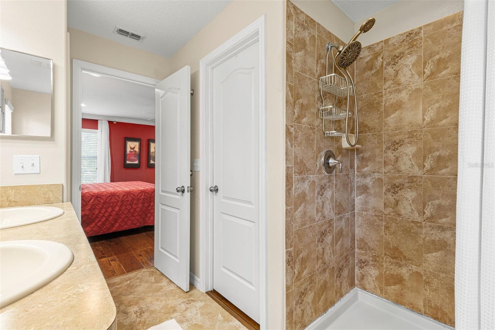 The primary bath includes a separate tiled shower with both fixed and handheld showerheads, conveniently located just off the bedroom. - 9524 TRUMPET VINE LOOP, NEW PORT RICHEY