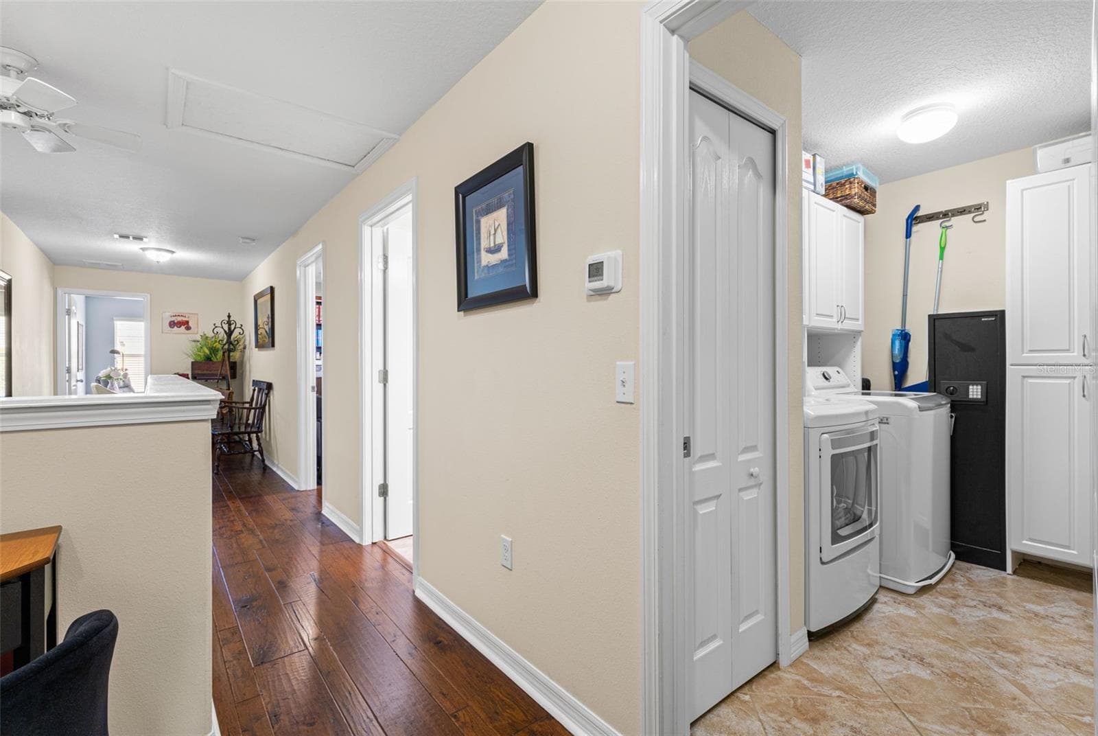 The second-floor laundry room keeps chores close to the bedrooms and includes a 2024 LG washer-and-dryer set, tile flooring and built-in storage. - 9524 TRUMPET VINE LOOP, NEW PORT RICHEY