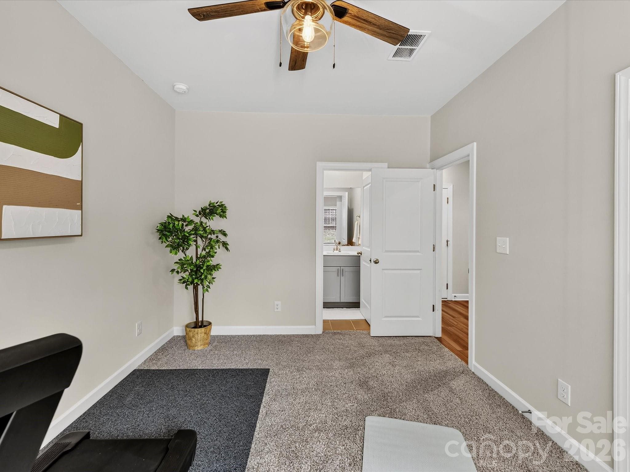 Versatile main-level bedroom with private en-suite bath is perfect for guests, a home office, or multi-generational living. - 4552 Millennium Avenue, Charlotte