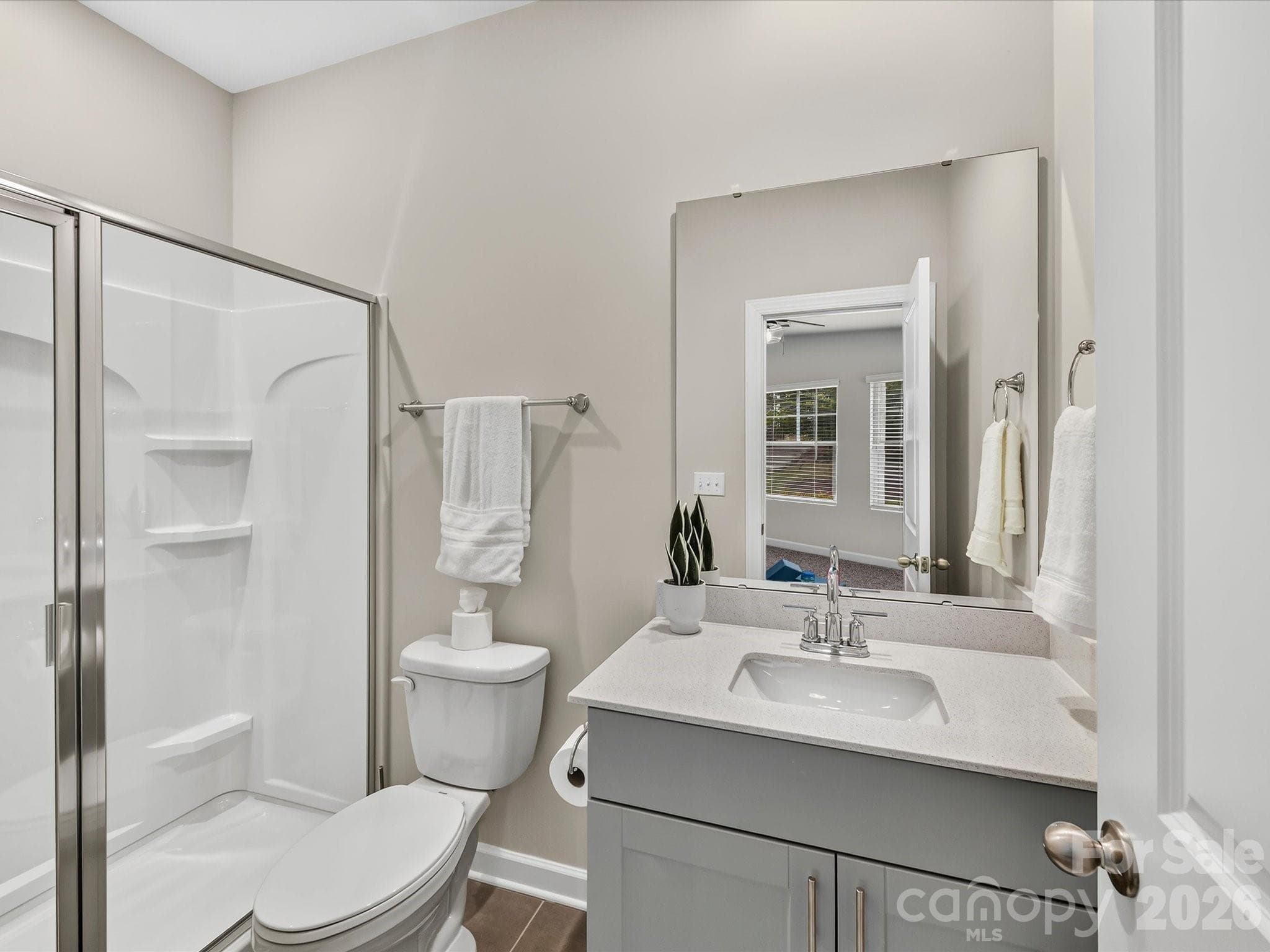 Private en-suite bathroom features a modern vanity and walk-in shower for added comfort and convenience. - 4552 Millennium Avenue, Charlotte