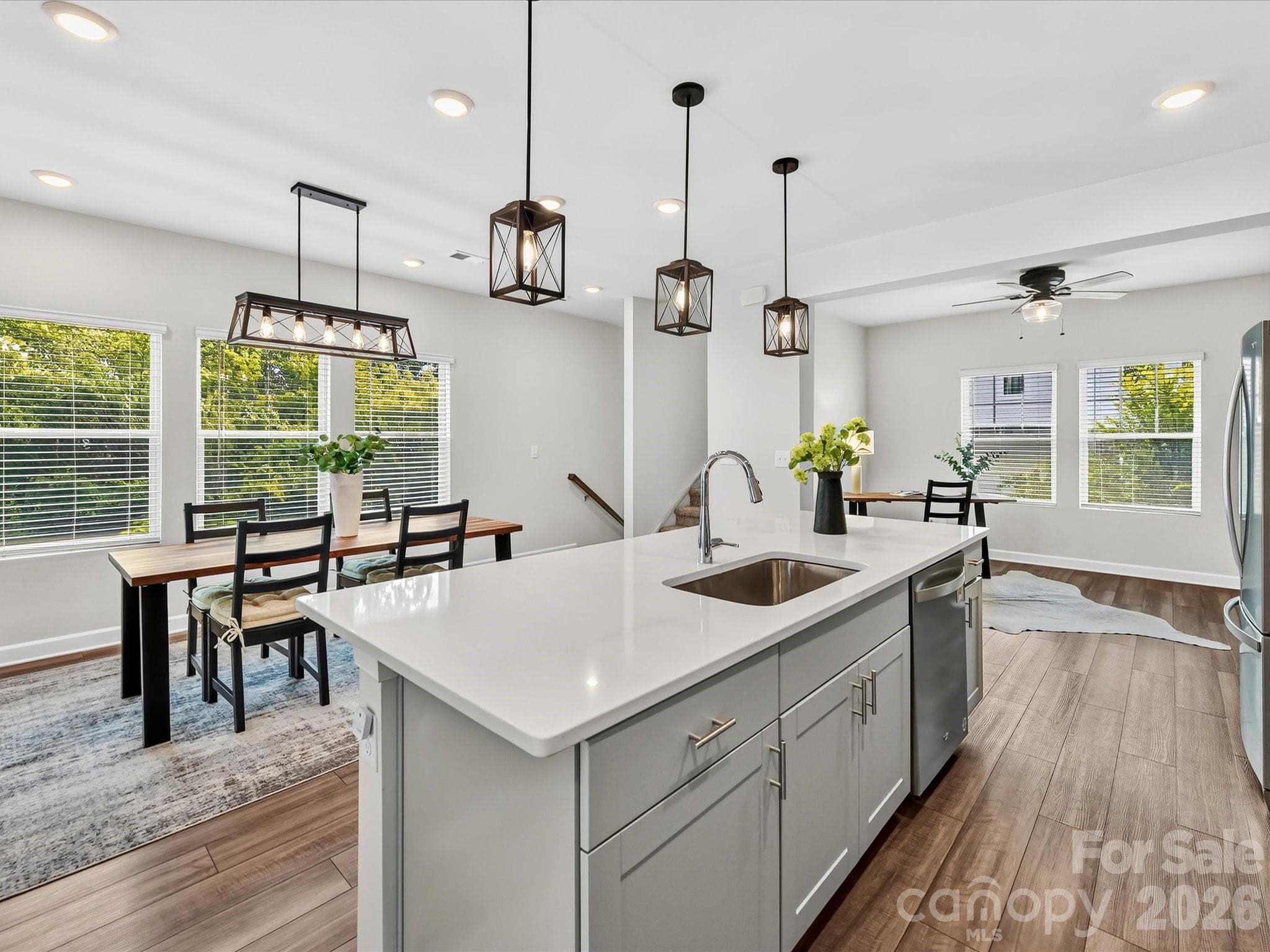 The chef-inspired kitchen showcases a large island, abundant cabinetry, stainless steel appliances, and designer lighting. - 4552 Millennium Avenue, Charlotte