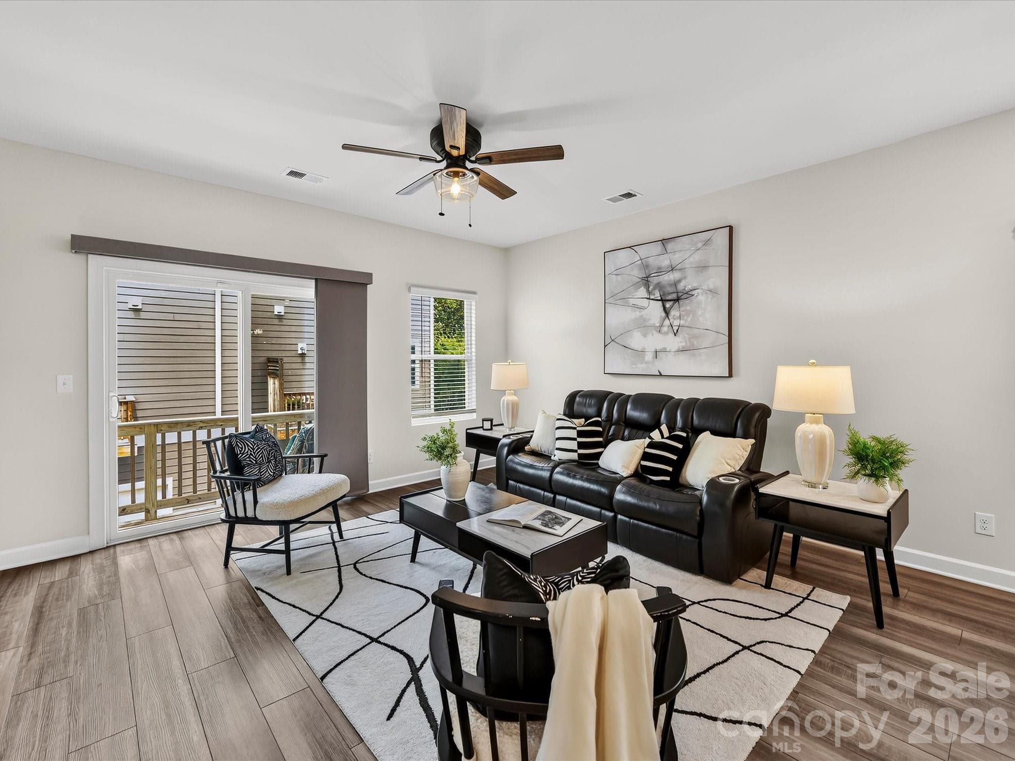 Bright and inviting family room features an open layout, abundant natural light, and seamless access to the outdoor deck for effortless indoor-outdoor living. - 4552 Millennium Avenue, Charlotte