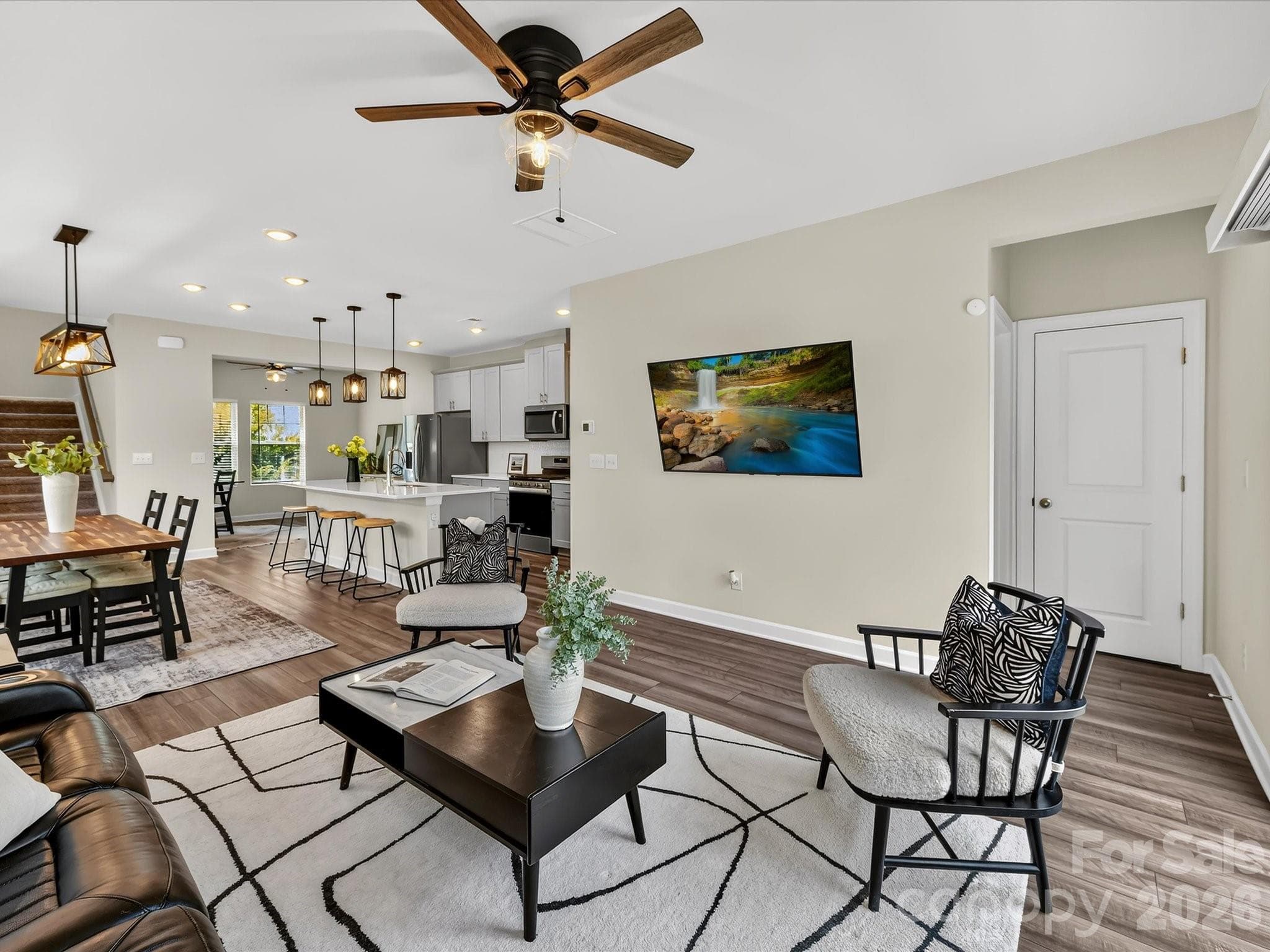 Spacious family room offers the perfect place to relax or entertain, complete with oversized windows, modern finishes, and an open-concept design. - 4552 Millennium Avenue, Charlotte