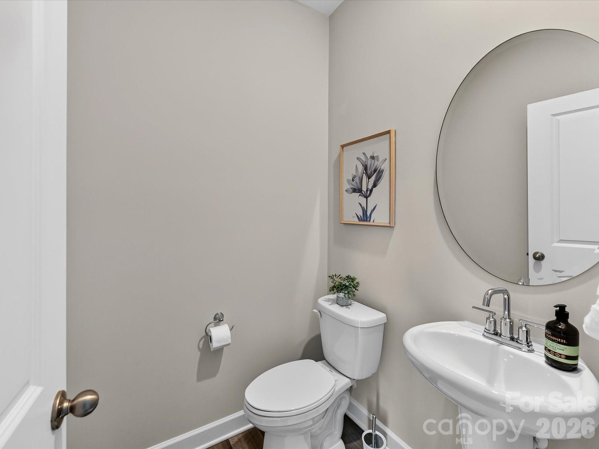 Convenient main-level powder room features stylish finishes for guests and everyday use. - 4552 Millennium Avenue, Charlotte