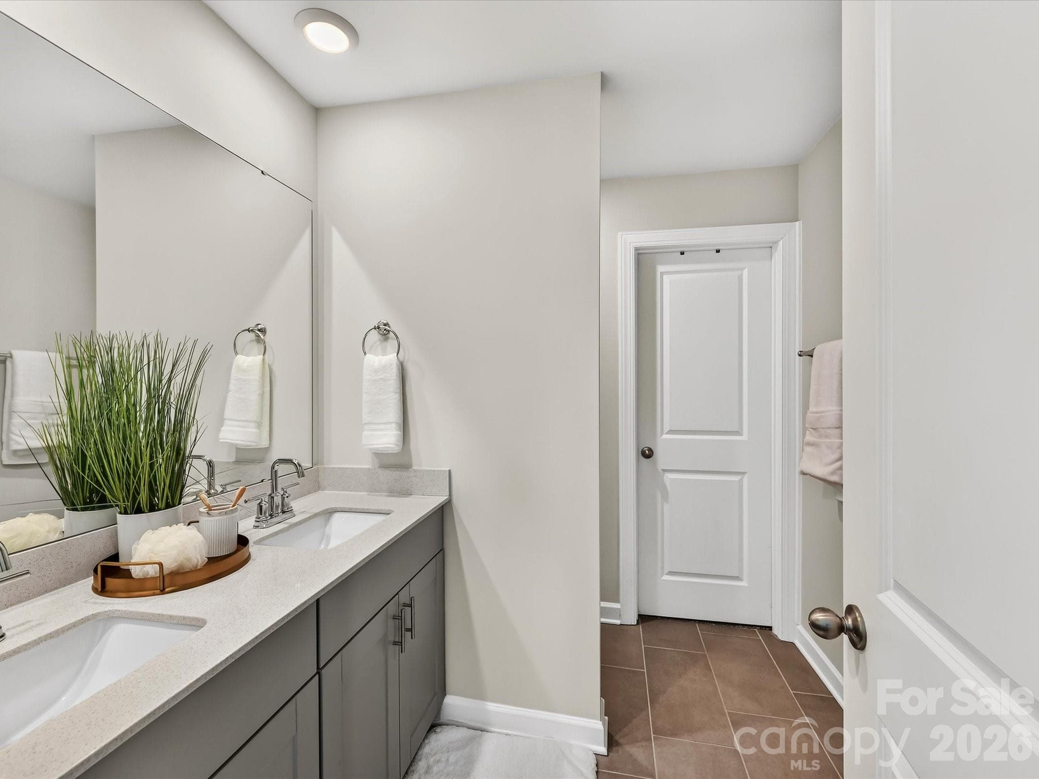 Spa-inspired primary bathroom features dual vanities, a spacious walk-in shower, and ample storage. - 4552 Millennium Avenue, Charlotte
