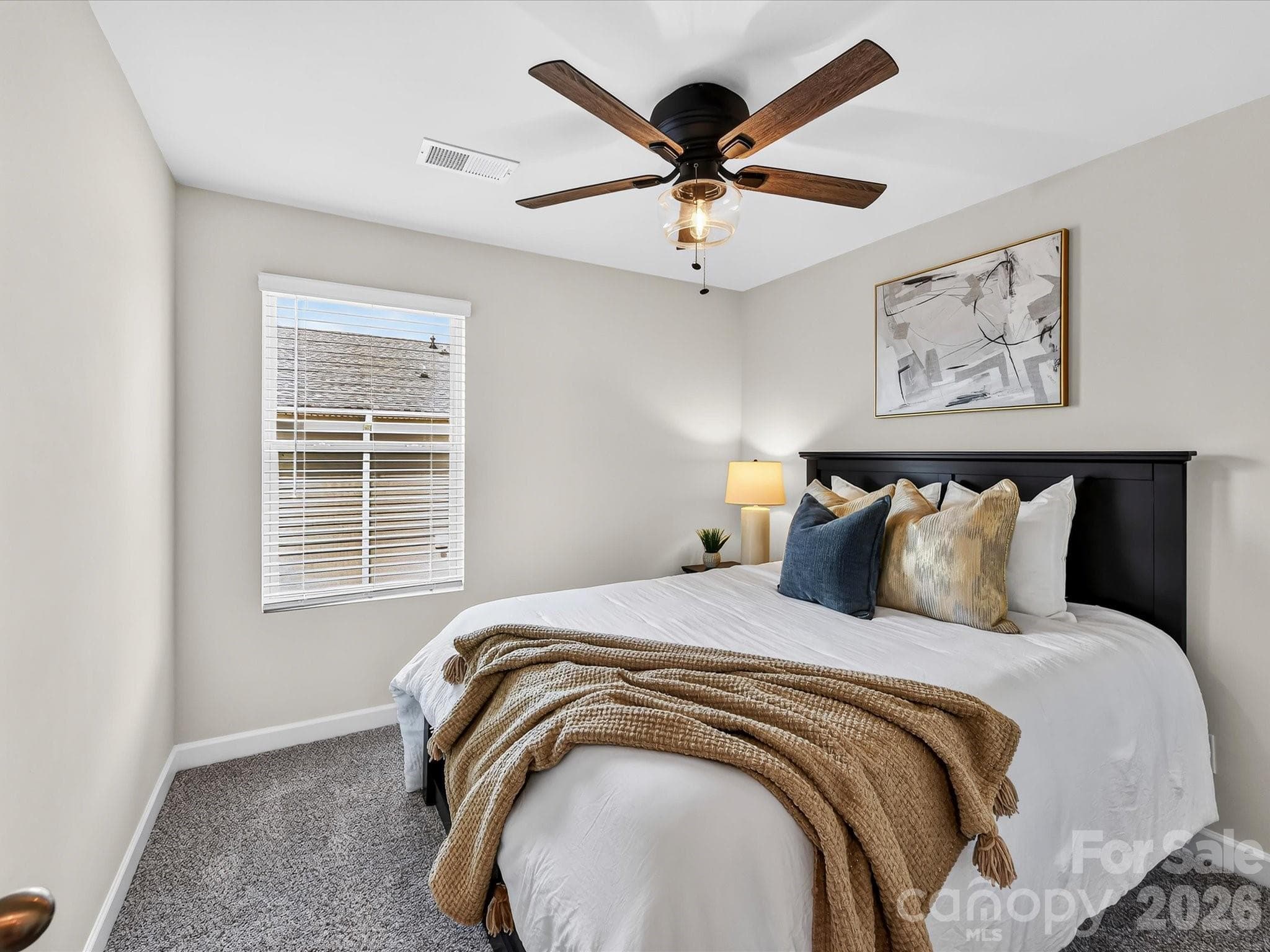 Bright secondary bedroom offers generous closet space and comfortable accommodations for family or guests. - 4552 Millennium Avenue, Charlotte
