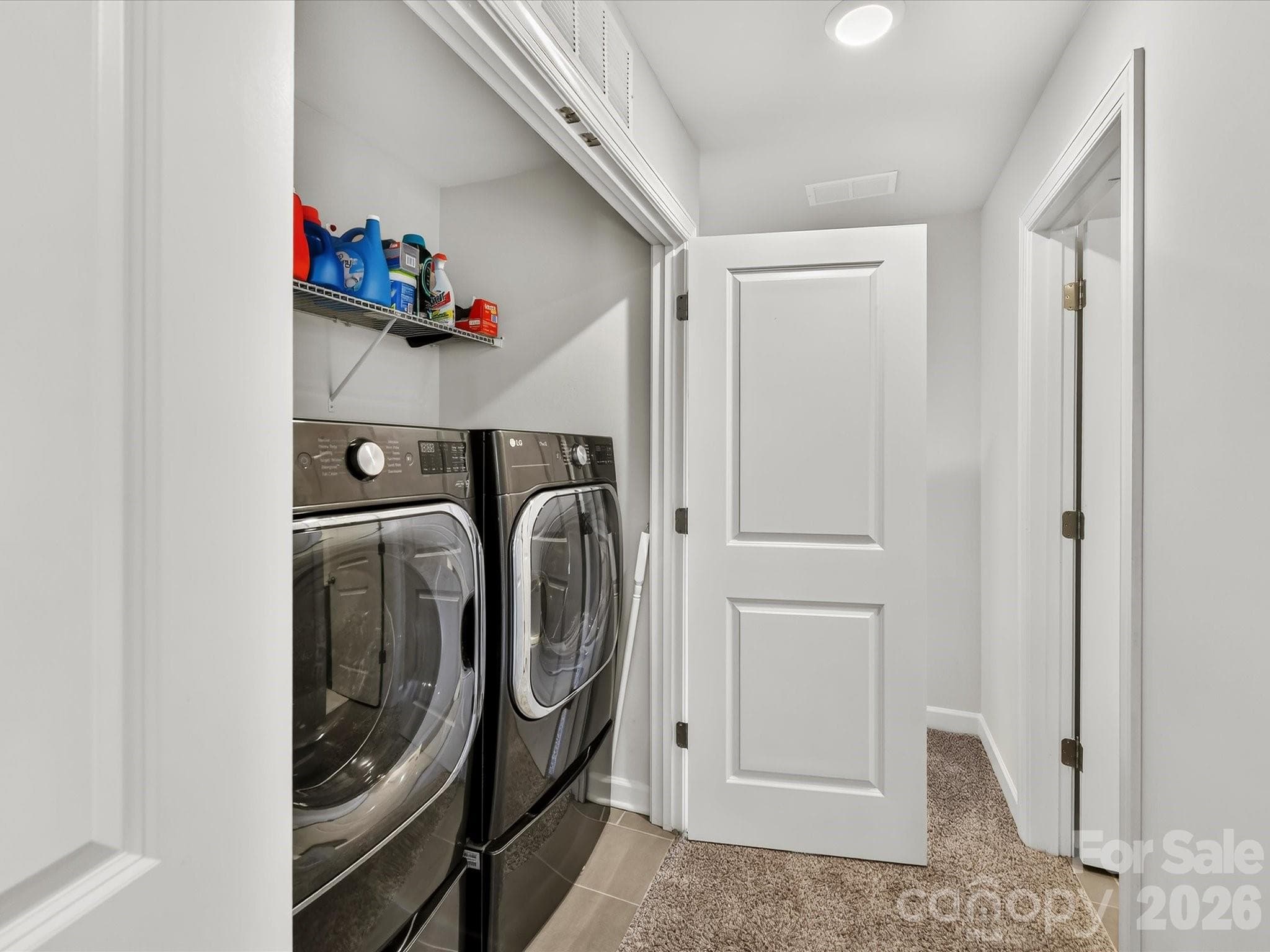 Convenient upper-level laundry area offers everyday functionality with built-in shelving for added storage and organization. - 4552 Millennium Avenue, Charlotte