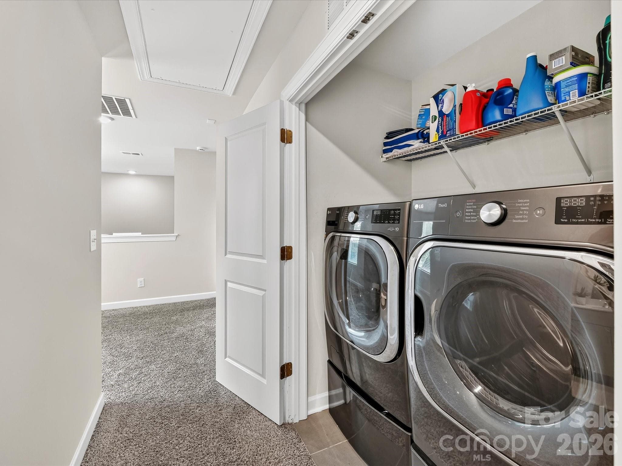 Convenient upper-level laundry area offers everyday functionality with built-in shelving for added storage and organization. - 4552 Millennium Avenue, Charlotte