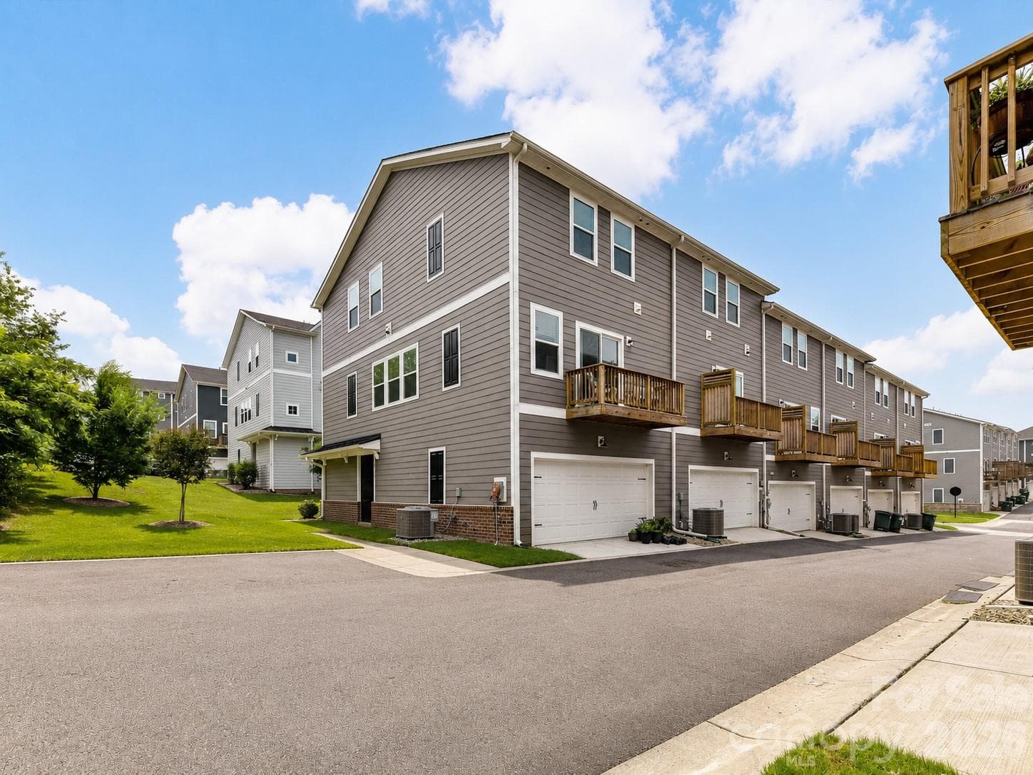 Rear exterior showcases a low-maintenance design with a private balcony, spacious two-car garage, and additional driveway parking. - 4552 Millennium Avenue, Charlotte