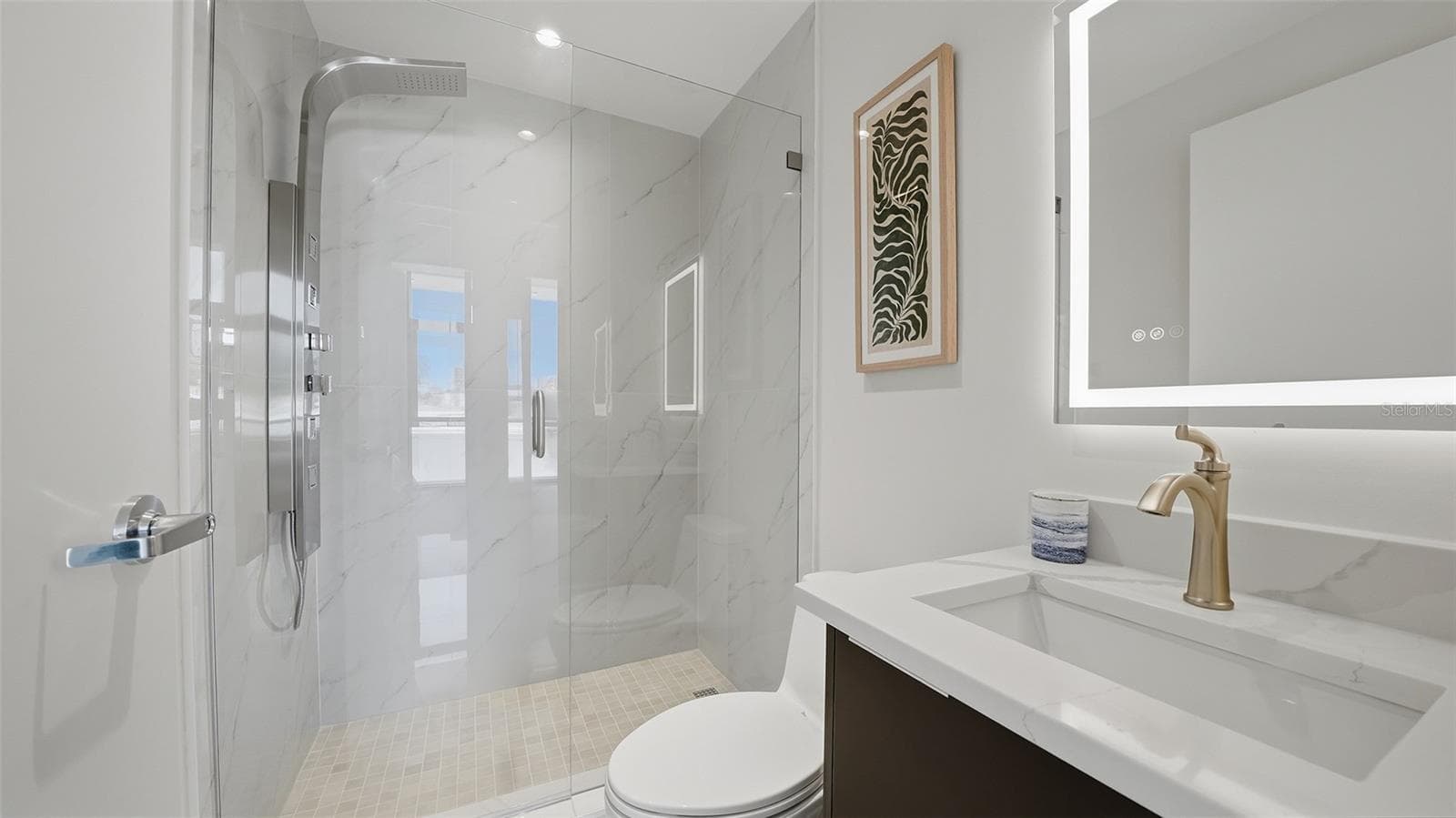 The guest bath off the hallway doubles as a powder room for visitors and features LED mirror, walk in 'power' shower with body jets and handheld shower and Euro glass shower enclosure. - 430 KUMQUAT CT #202, SARASOTA