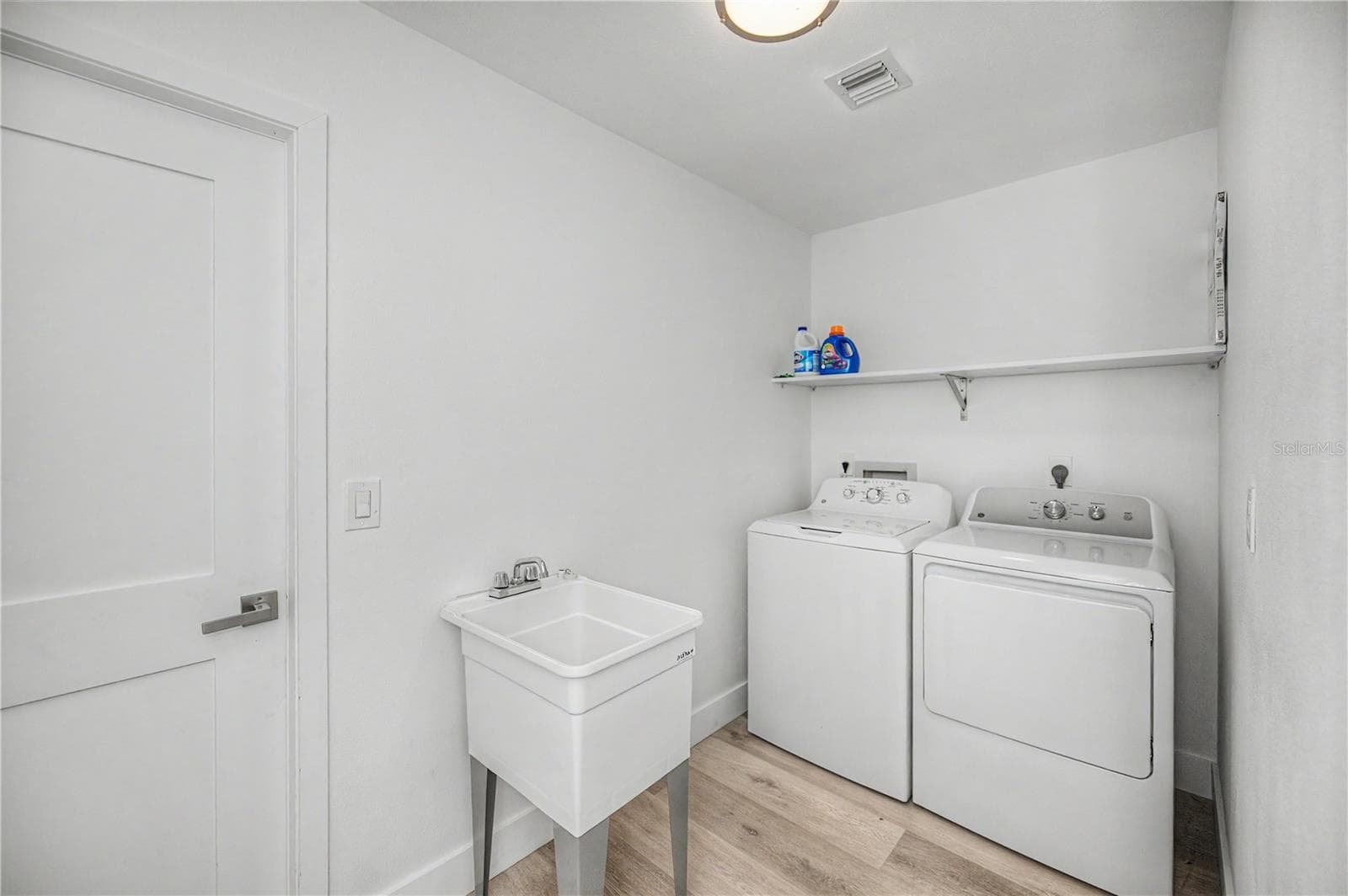 Inside laundry room with storage closet and utility sink - 8152 SEASHELL ST, ENGLEWOOD