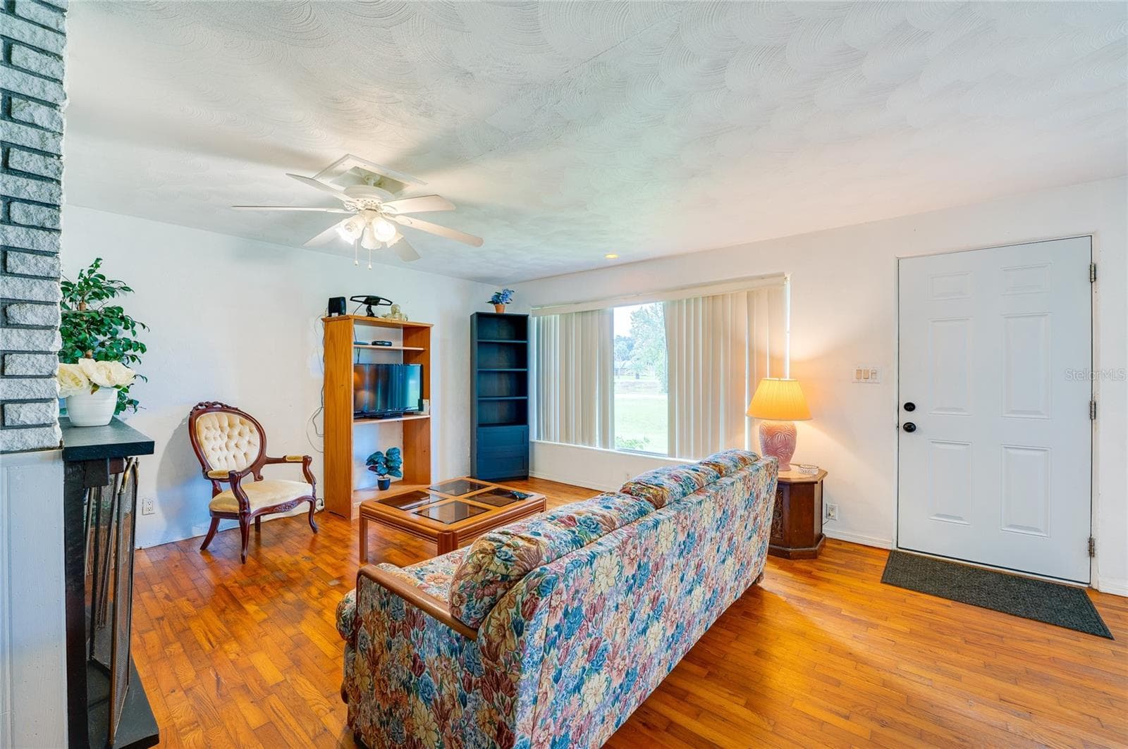 Bright entryway and living zone showcasing gleaming hardwood floors, and a classic front door. Generous windows allow daylight to fill the open interior layout. - 1101 16TH ST, EDGEWATER