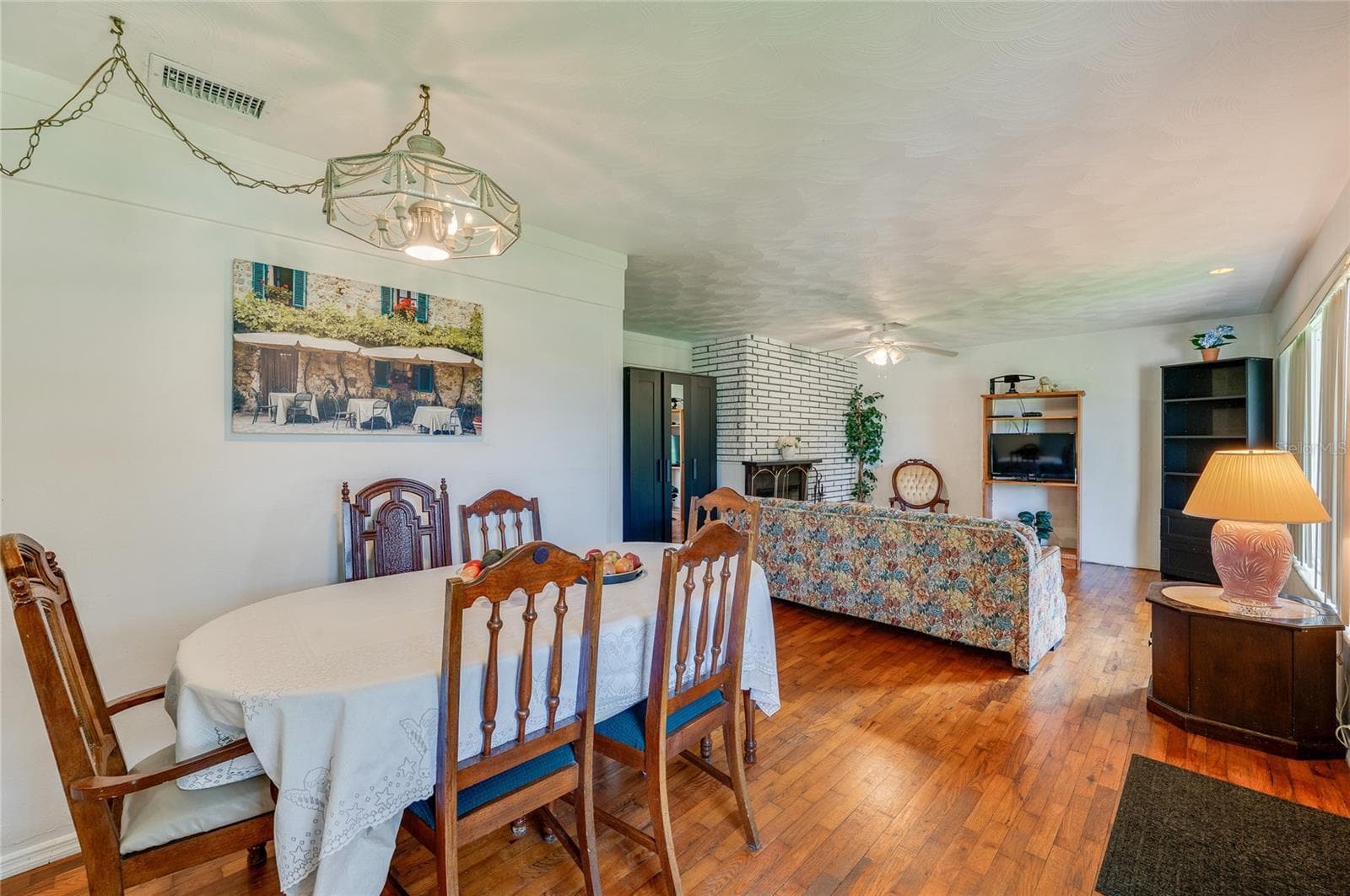 Expansive living and dining area highlighted by continuous hardwood flooring, clean neutral walls, and a hanging light fixture. The flexible open floor plan offers a bright atmosphere with smooth visual transitions. - 1101 16TH ST, EDGEWATER