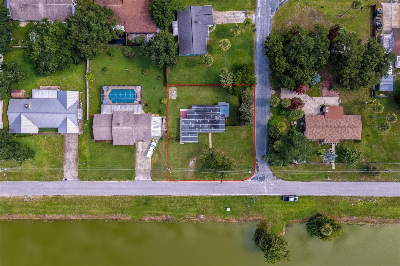 High-altitude aerial photograph highlighting the home's position near the neighborhood pond, surrounding woodland, and proximity to local community amenities. - 1101 16TH ST, EDGEWATER
