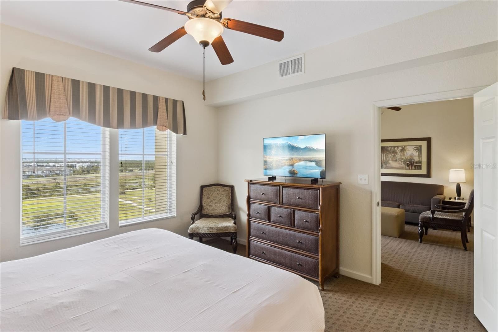 Primary Bedroom View | Large windows provide abundant daylight and elevated views across the resort pool and grounds. - 8101 RESORT VILLAGE DR #31110, ORLANDO
