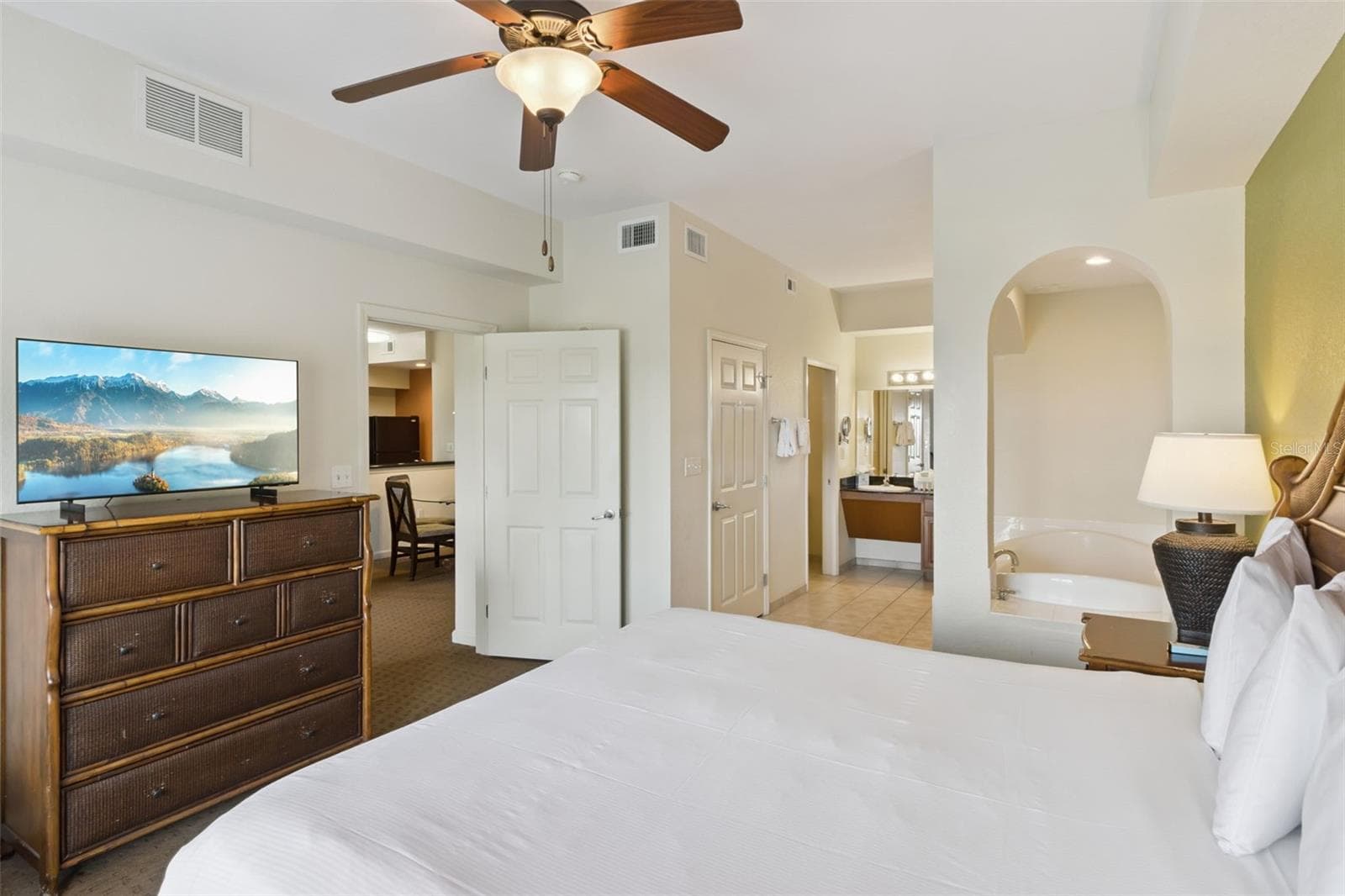 Primary Suite | An arched opening and connected bath create a suite-style arrangement. - 8101 RESORT VILLAGE DR #31110, ORLANDO