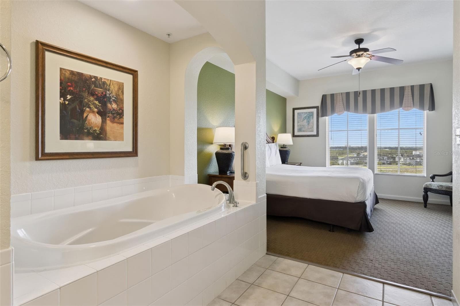 Primary Bath | A deep soaking tub opens toward the bedroom, creating a relaxing retreat within the suite. - 8101 RESORT VILLAGE DR #31110, ORLANDO